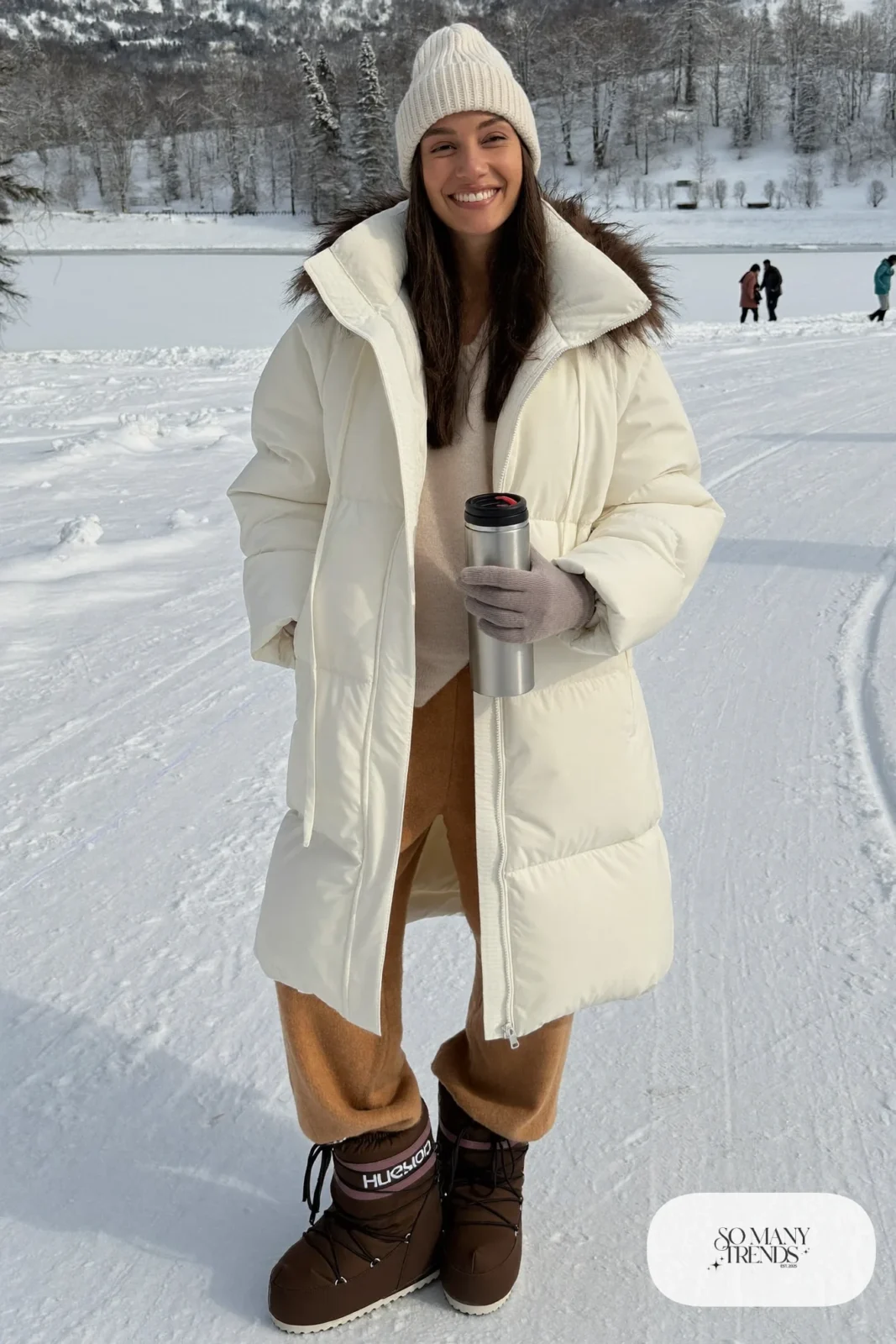 long white down parka faux fur hood camel knit pants brown snow boots cream beanie outfit 26