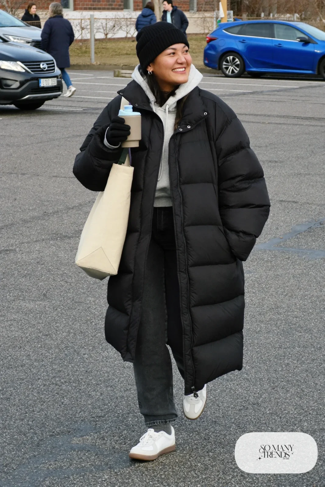 long black matte puffer coat gray hoodie dark straight stretch jeans white sneakers black beanie canvas tote outfit 7