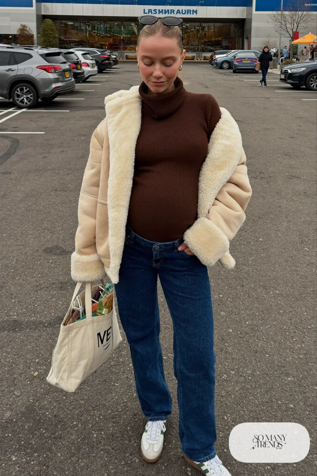 pregnant woman in maternity jeans, chocolate brown ribbed turtleneck, oversized shearling jacket and white sneakers, outfit 7