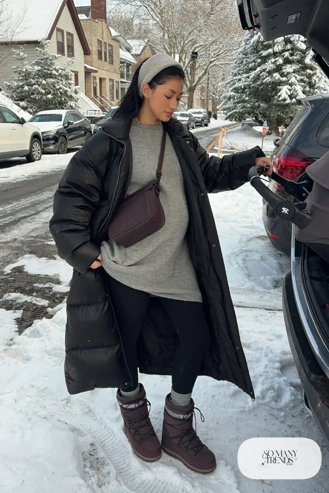 pregnant woman in long black puffer coat, black leggings, gray oversized sweater and insulated winter boots, outfit 8