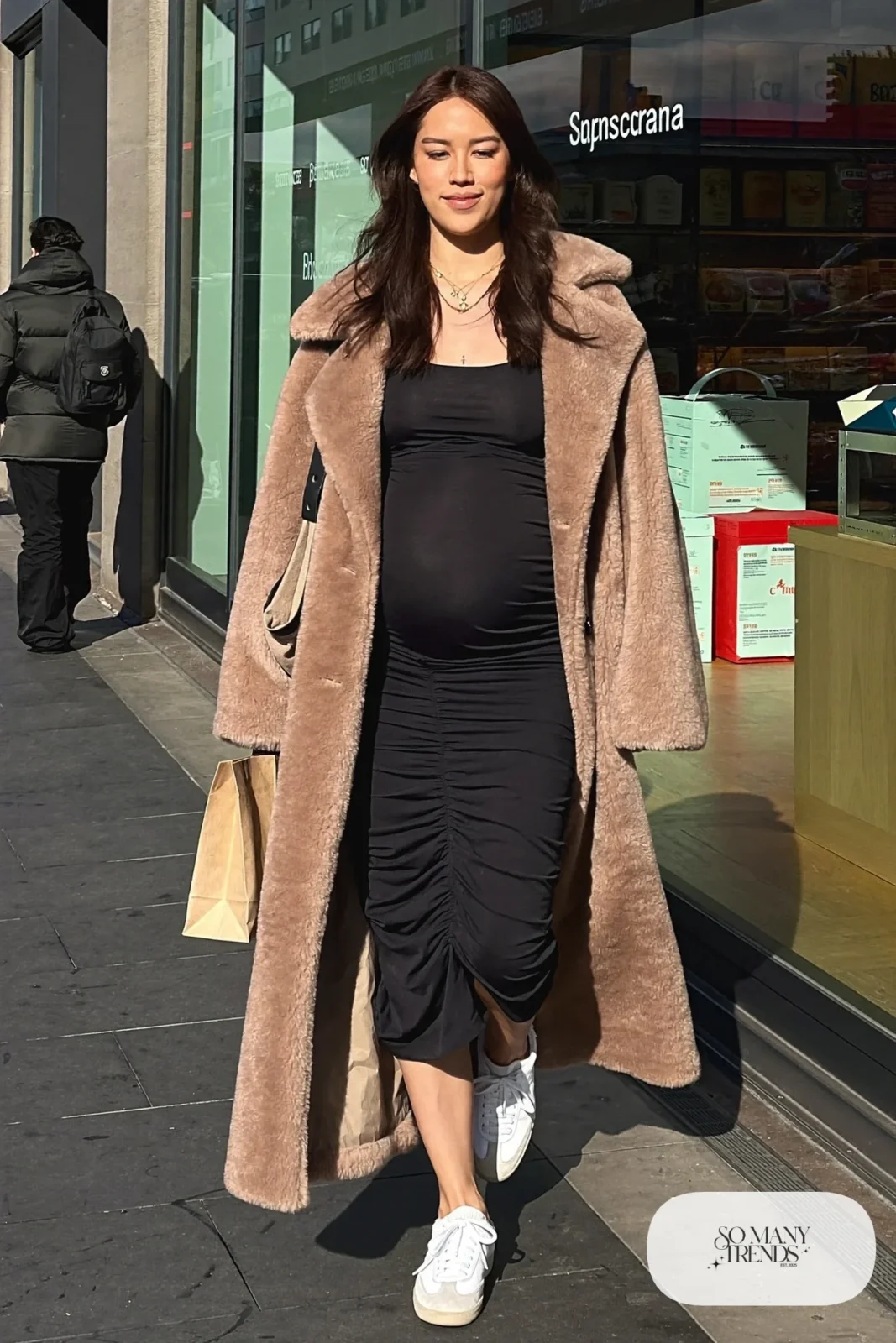 pregnant woman in black ruched jersey dress, camel teddy coat, white sneakers and canvas tote, outfit 11