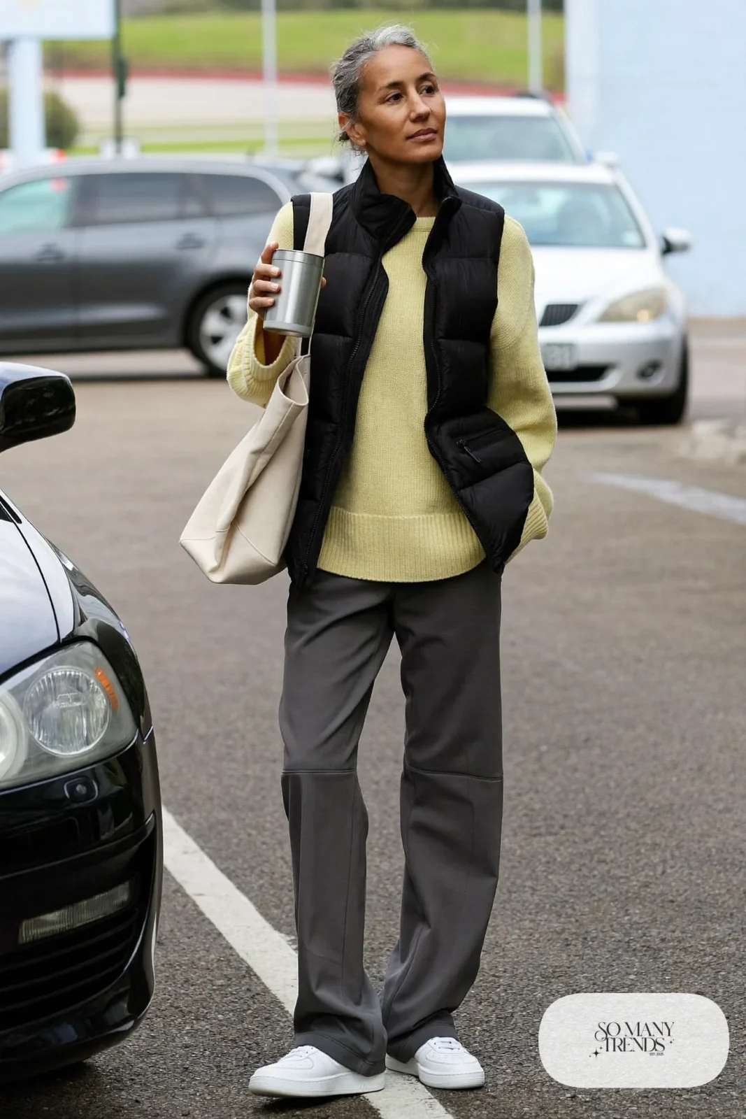 butter yellow sweater gray tailored joggers black puffer vest white sneakers tote outfit 12
