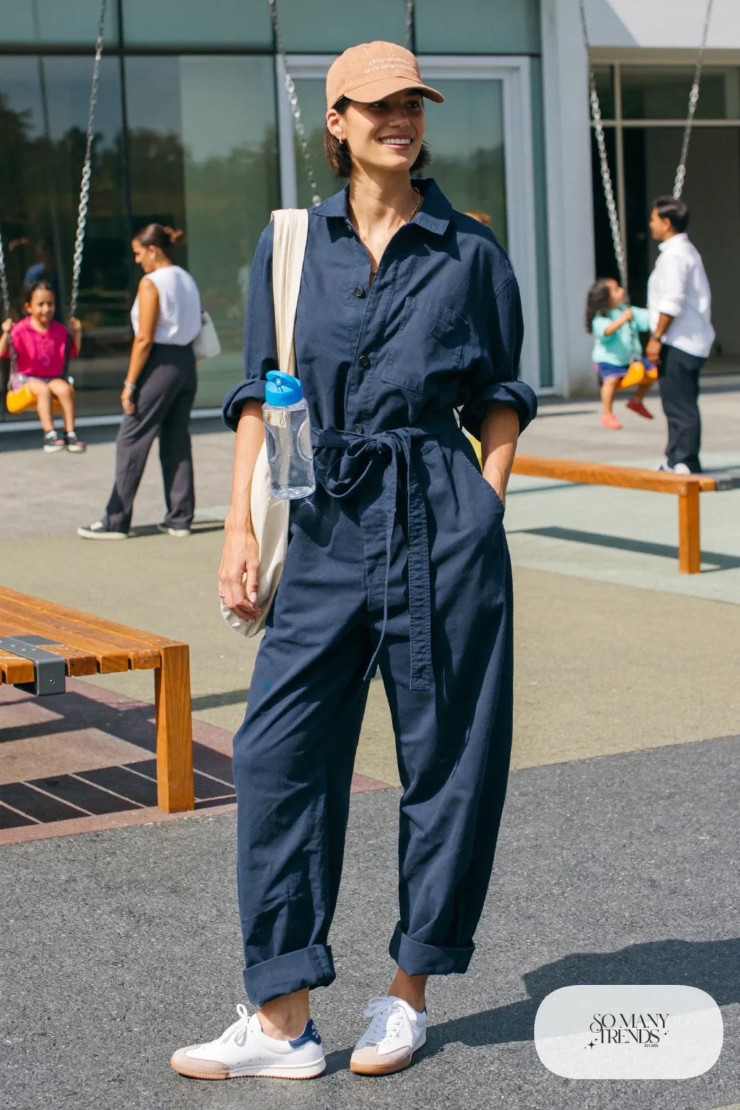 navy utility jumpsuit rolled cuffs white sneakers canvas tote baseball cap outfit 15