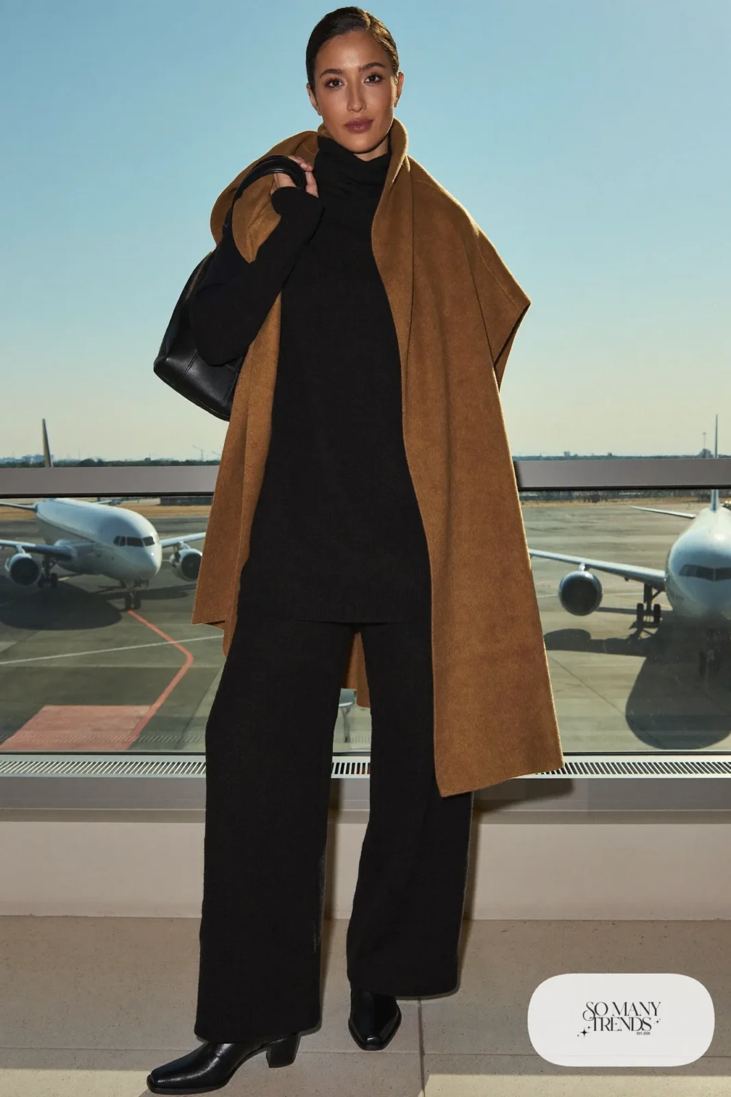 large camel wool wrap black turtleneck black wide pants black boots leather backpack travel outfit 29