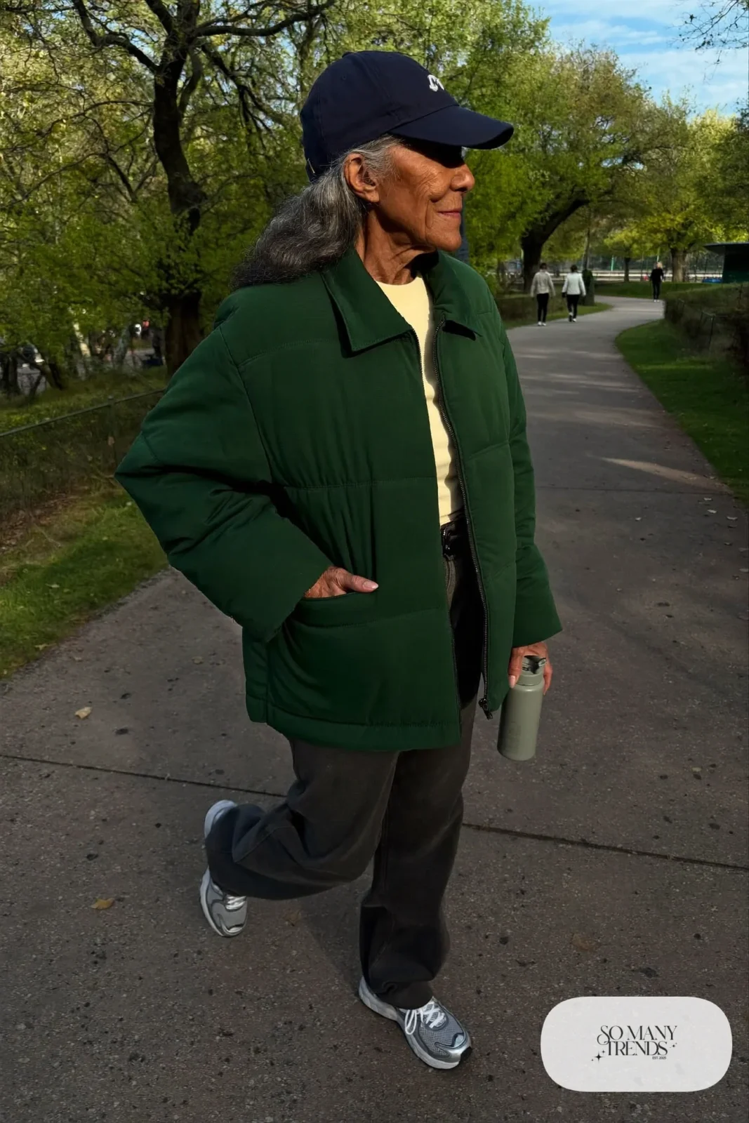 forest green quilted jacket with cream tee, charcoal soft pants and gray cushioned sneakers outfit 13