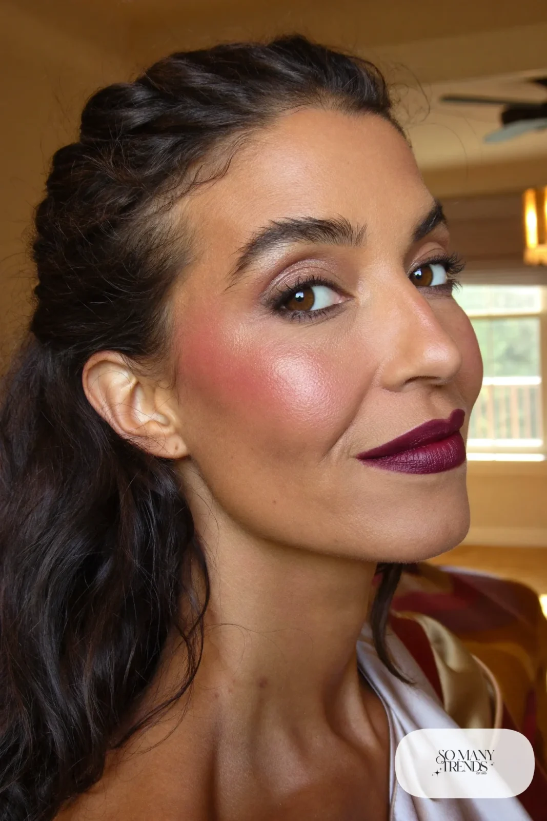 woman with deep berry lipstick, bronzed cheeks and glowing olive skin, makeup look 2