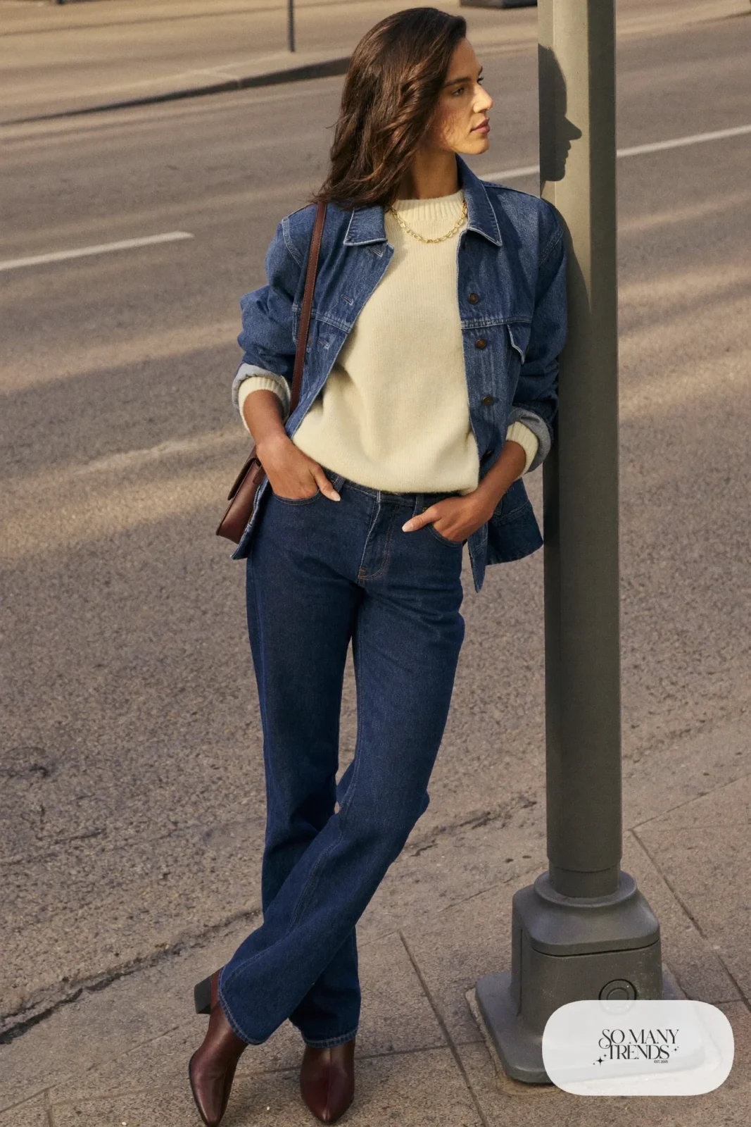 mid-wash denim jacket dark jeans cream knit brown leather boots gold chain crossbody outfit 18