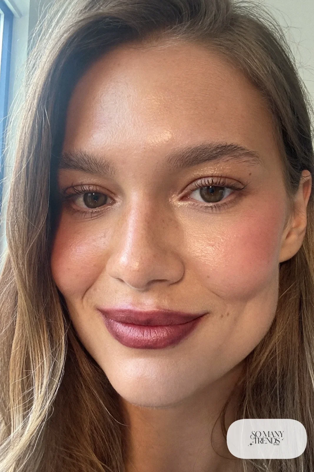 woman with sheer berry lip stain, rosy cheeks and natural lashes, winter makeup look 1
