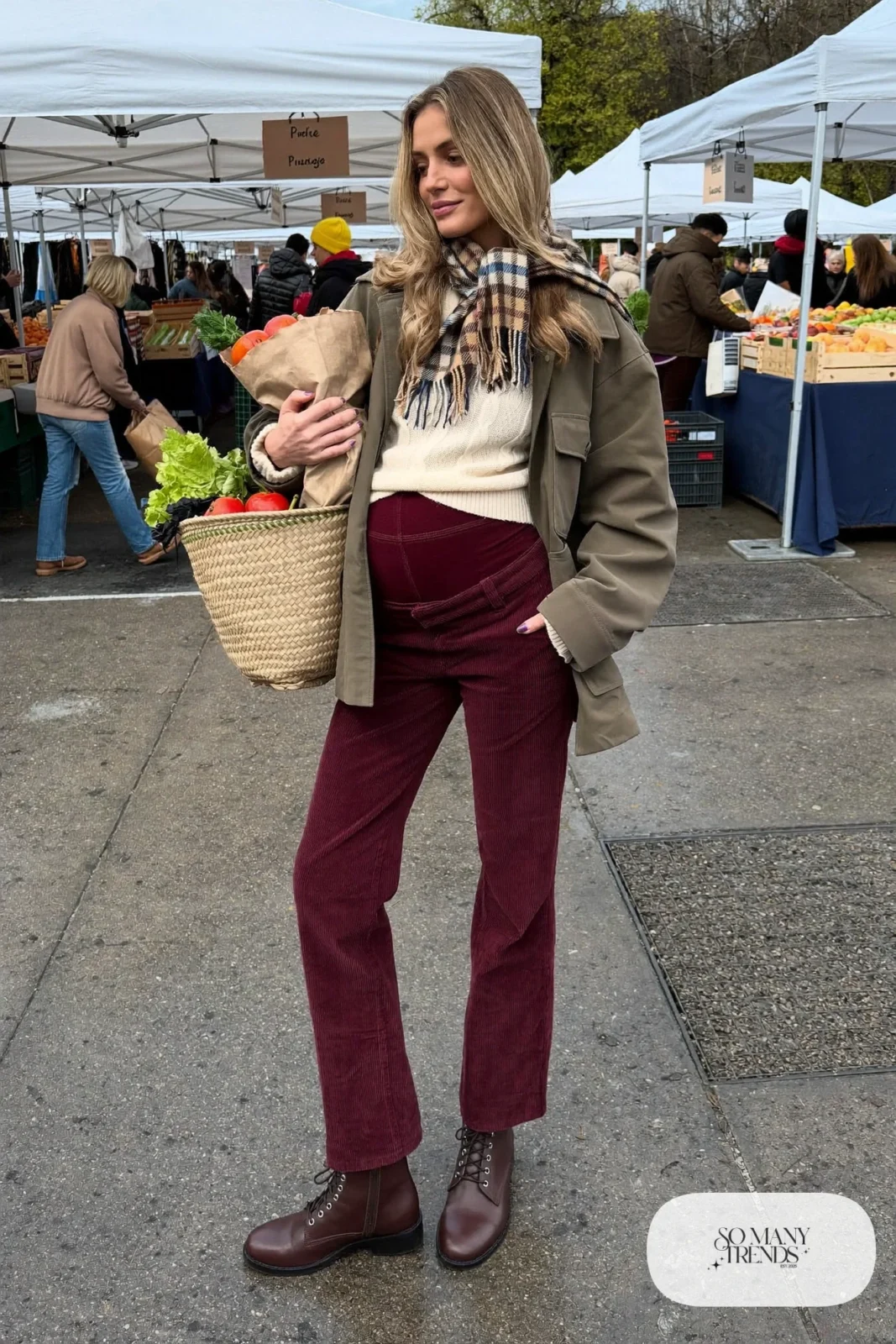 pregnant woman in burgundy corduroy maternity pants, cream cable-knit sweater, plaid scarf and brown boots, outfit 10