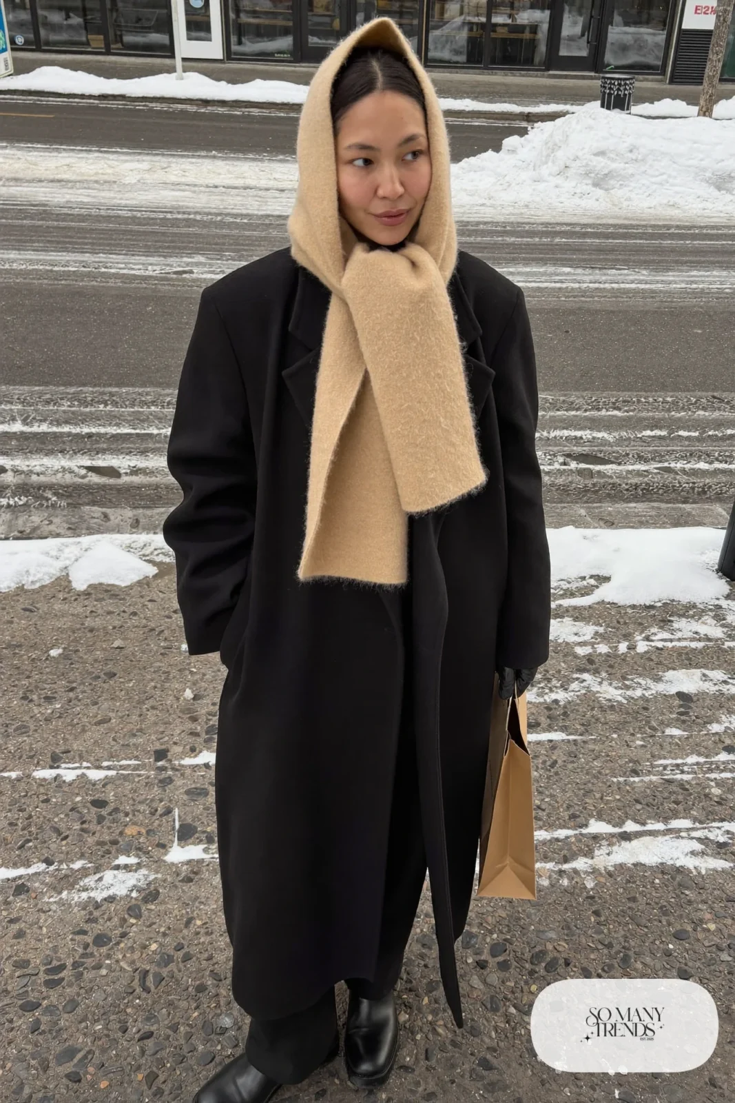 black long coat wide beige scarf worn over head black pants black boots black gloves outfit 12