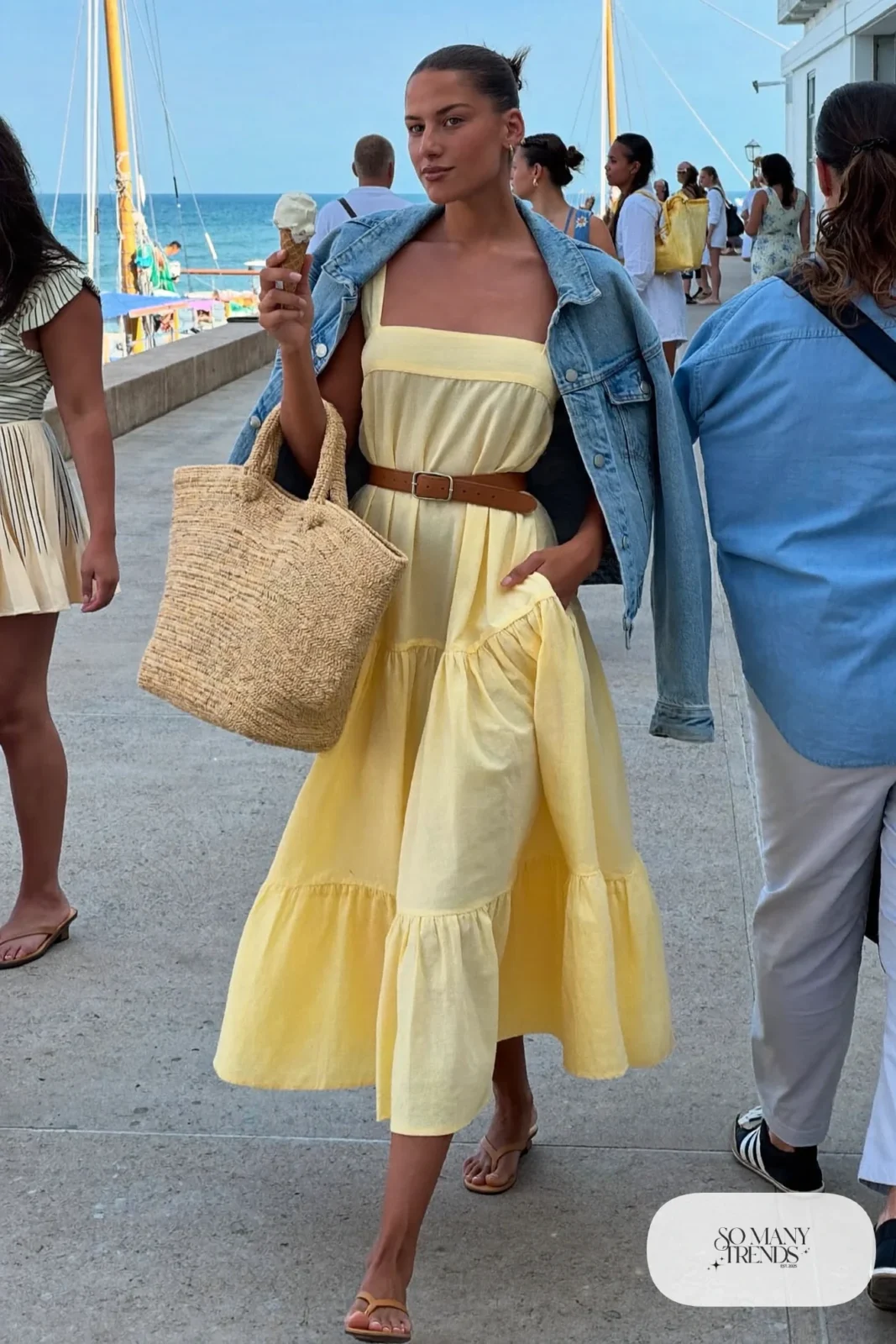 butter yellow tiered cotton midi dress tan belt denim jacket flat sandals straw tote outfit 20