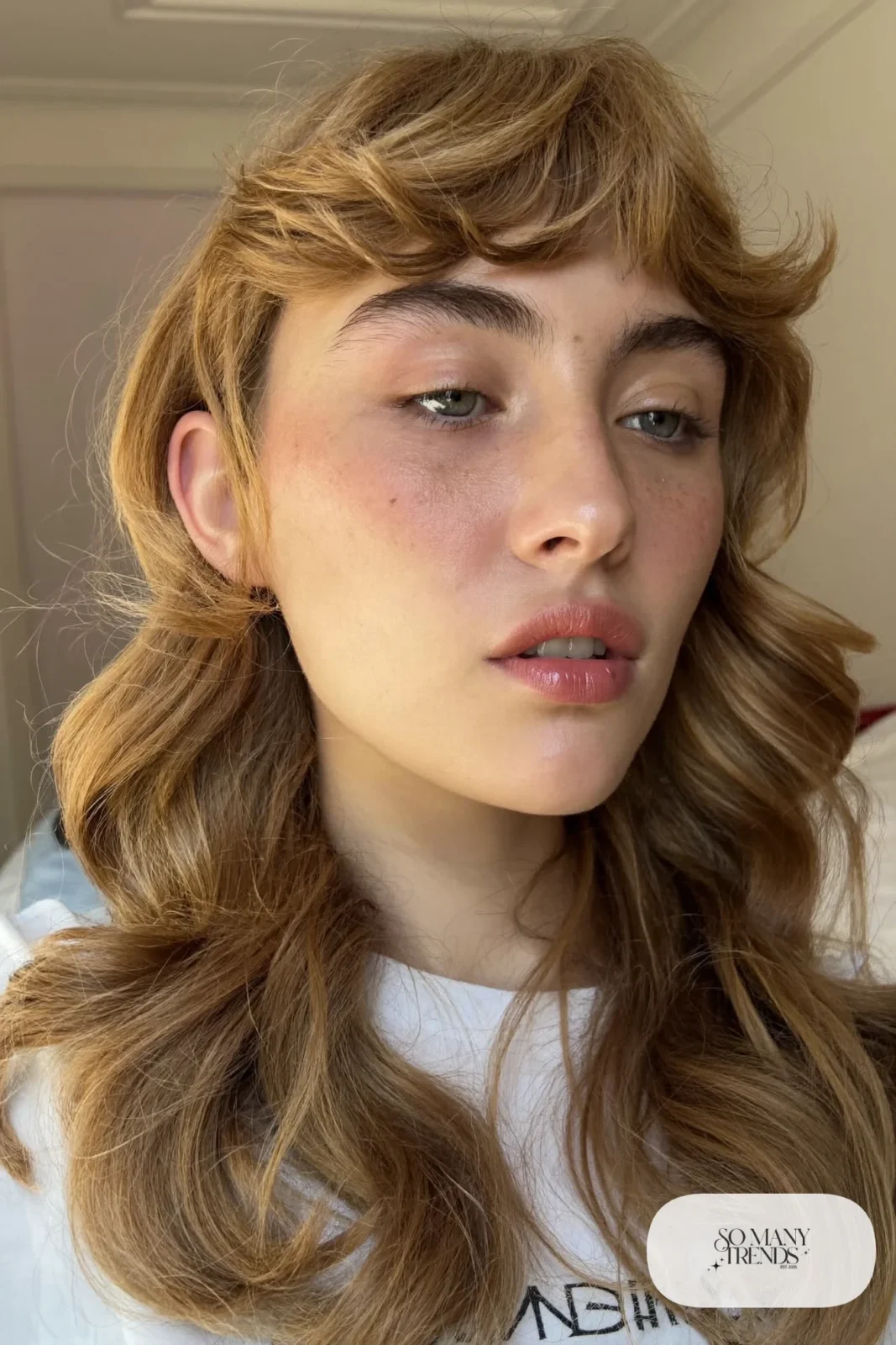 woman with honey blonde butterfly layered wavy hair worn down, natural makeup, haircut 2
