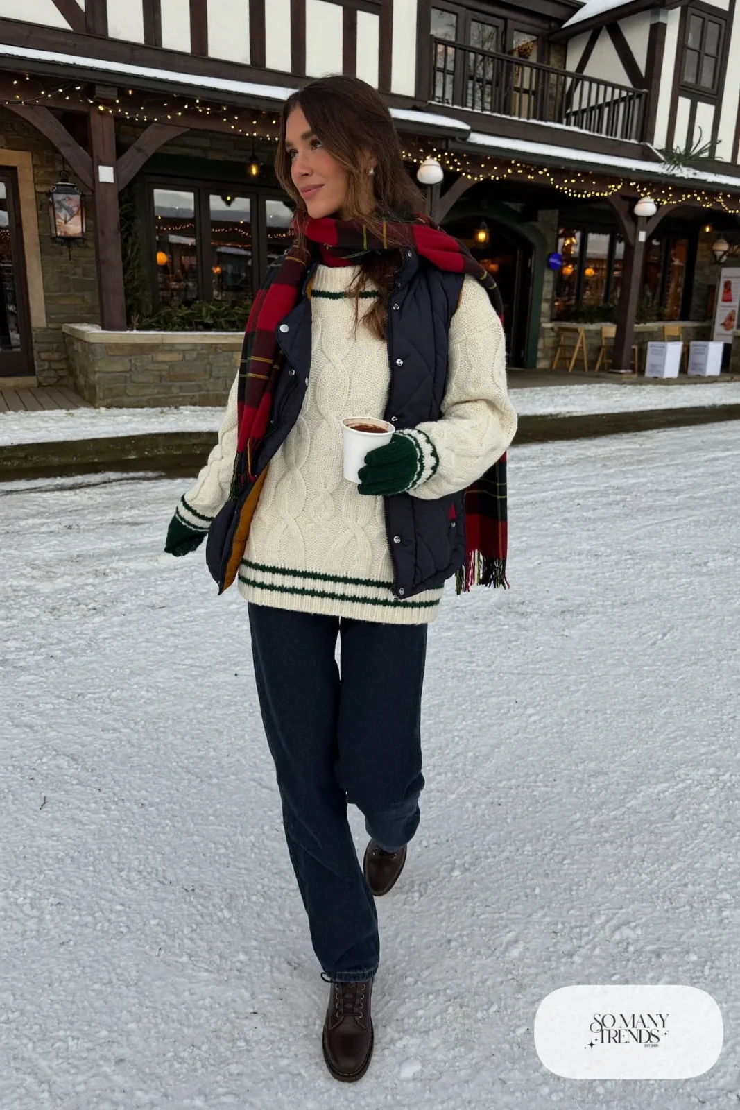 thick cream fisherman sweater red green tartan scarf dark jeans brown lace-up boots navy quilted vest outfit 28