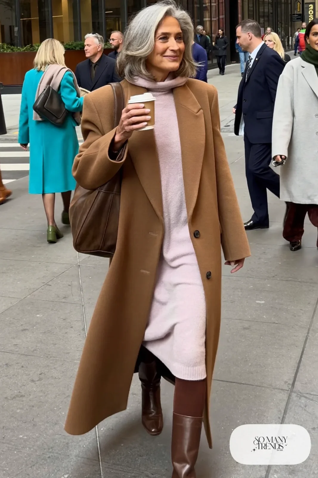 Woman in her fifties in a pale pink knit midi dress, camel belted coat, brown tights and heeled boots, outfit 4