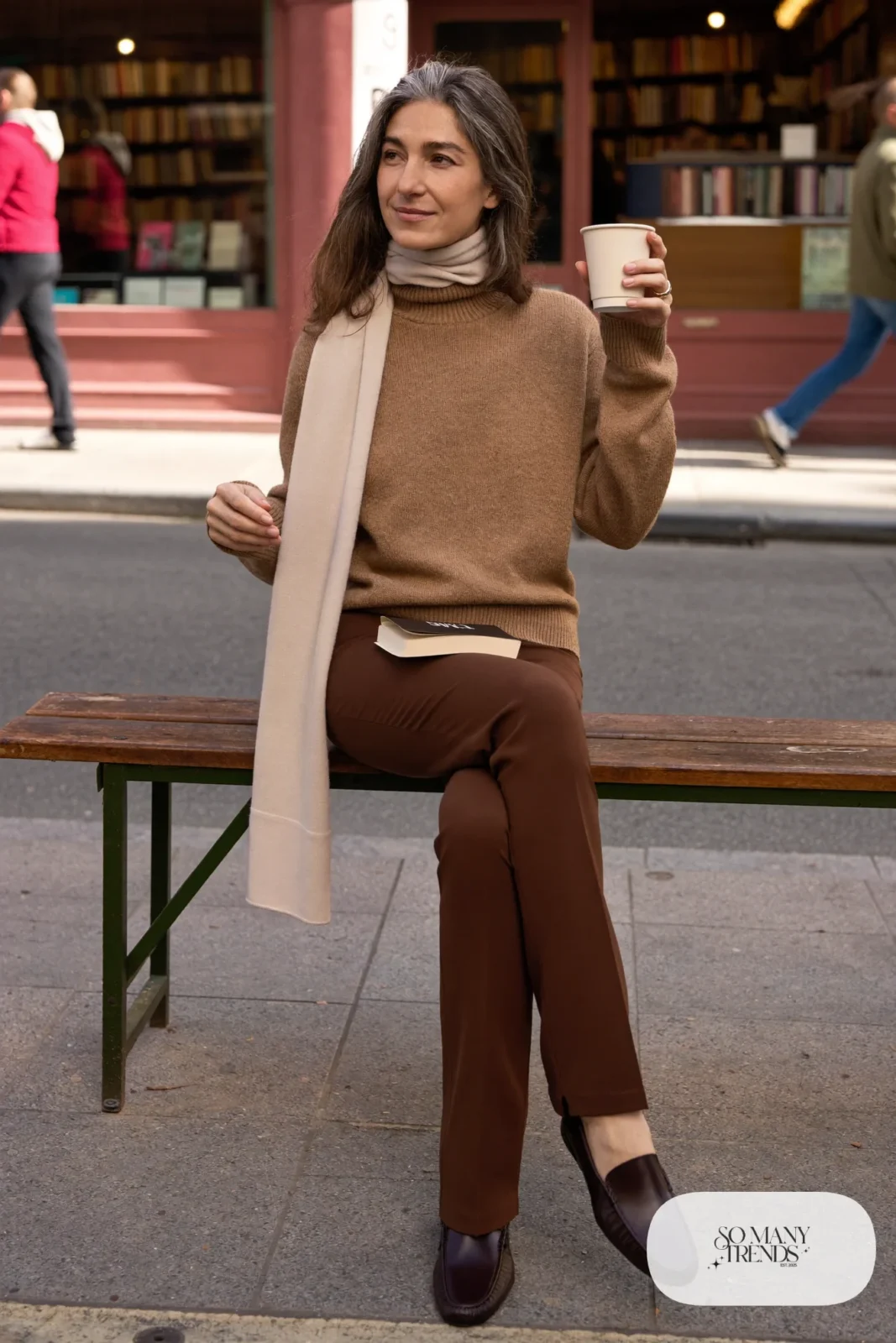 Woman in her fifties in a camel turtleneck sweater, slim espresso pants, loafers and a long scarf, outfit 13