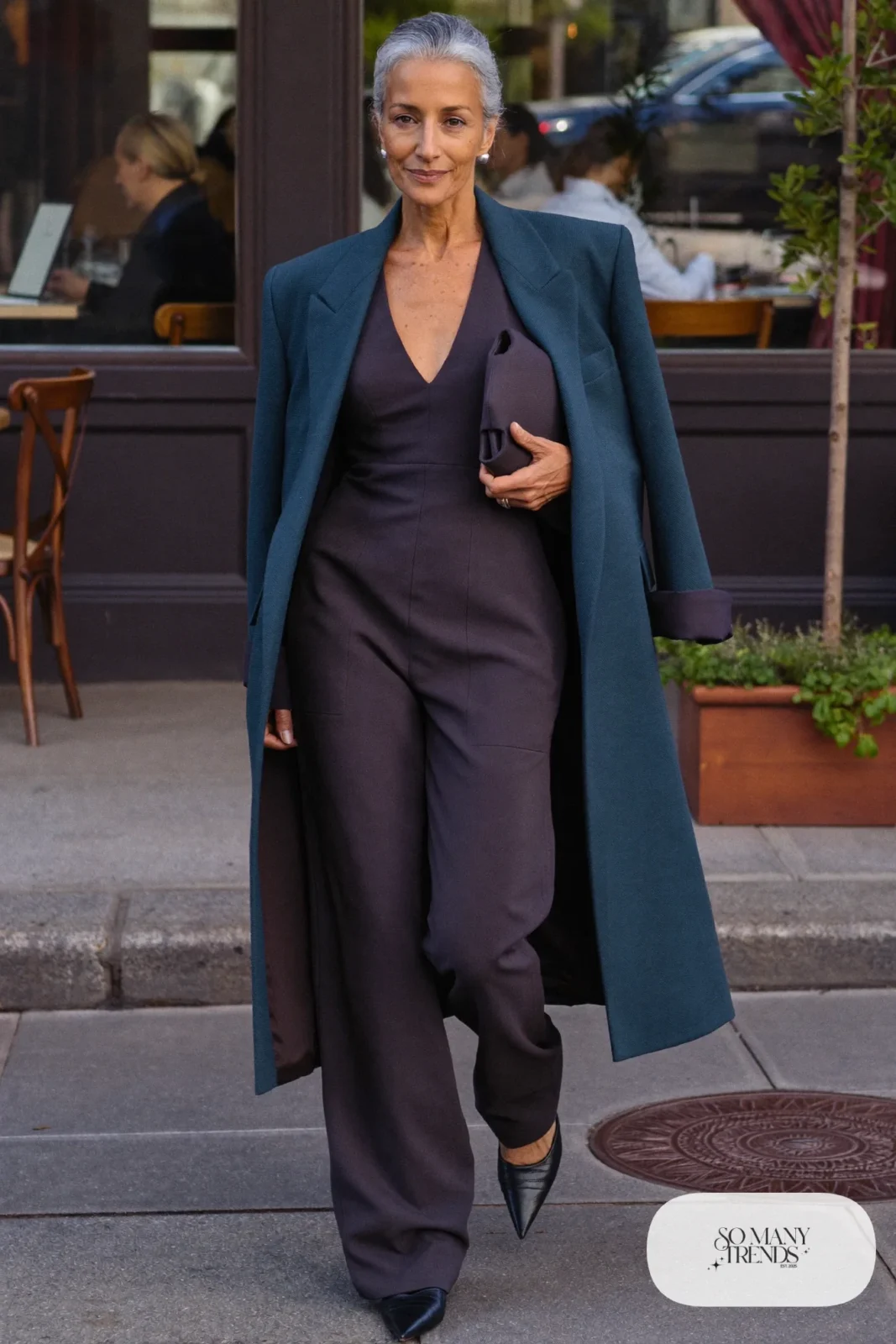 Woman in her fifties in a charcoal wide-leg jumpsuit, long teal blazer and black pointed flats, outfit 18