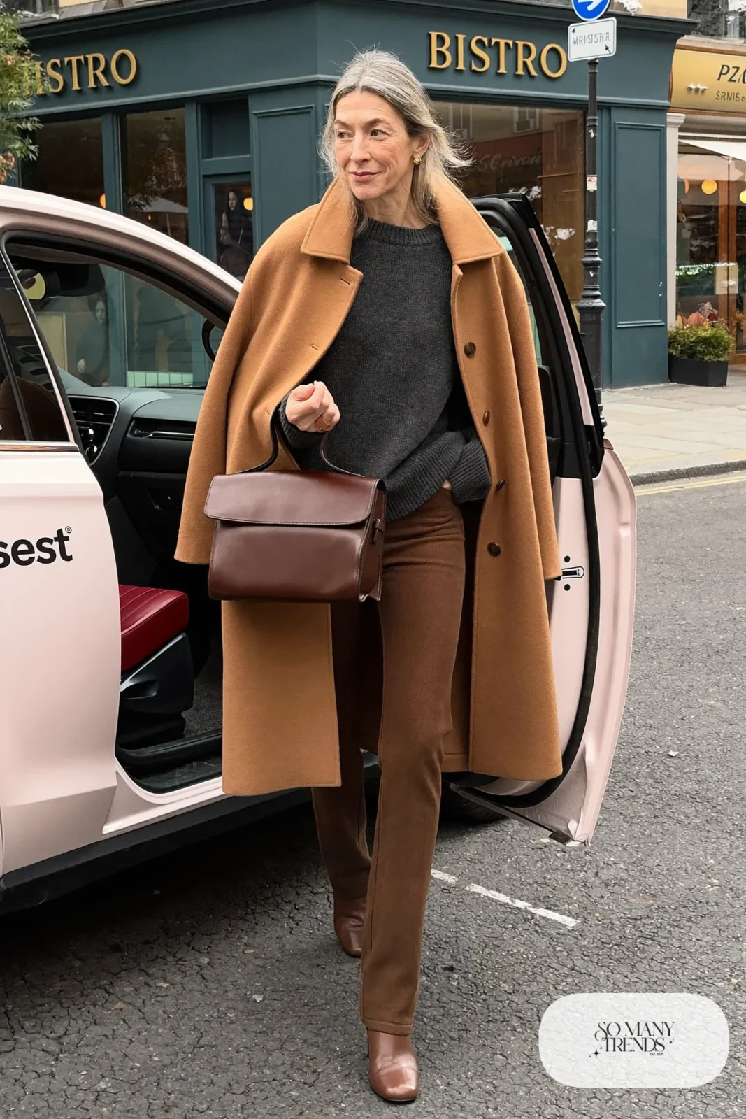 Woman in her fifties in a camel cape coat, charcoal knit, slim pants and low-heel boots, outfit 21