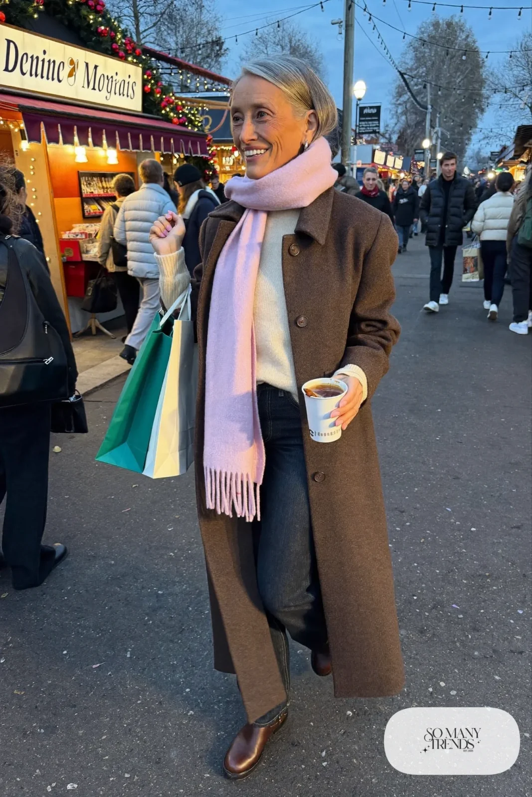 Woman in her fifties in a long charcoal coat, pale pink scarf, straight jeans and lug-sole boots, outfit 26