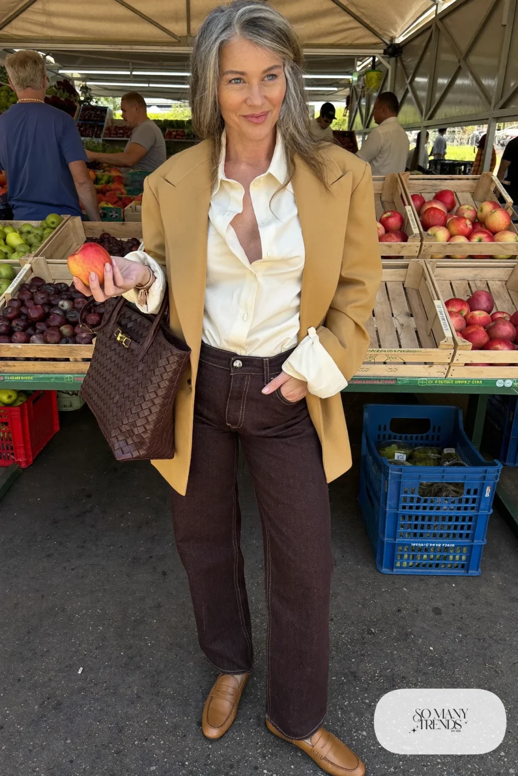 Woman in her sixties wearing dark straight jeans, a camel blazer, a cream blouse and tan loafers, outfit 8