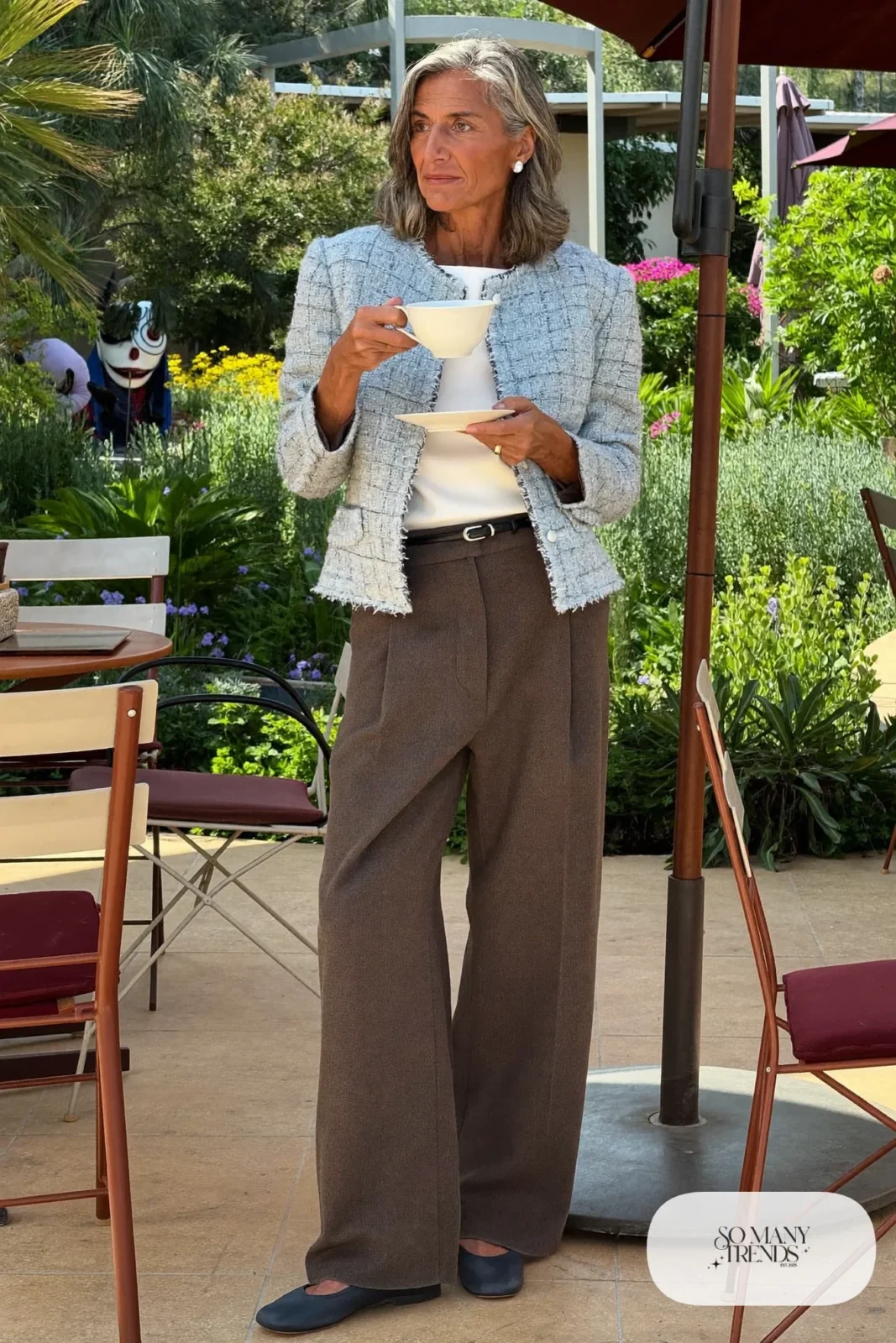 Woman in her sixties wearing a powder blue tweed jacket, gray wide-leg pants, a white shell and navy flats, outfit 10