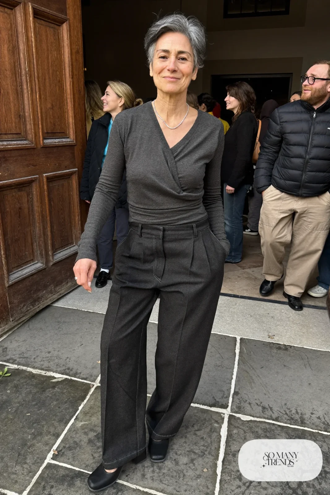 Petite woman in a charcoal wrap top with full-length charcoal wide-leg pants and block heels, outfit 6