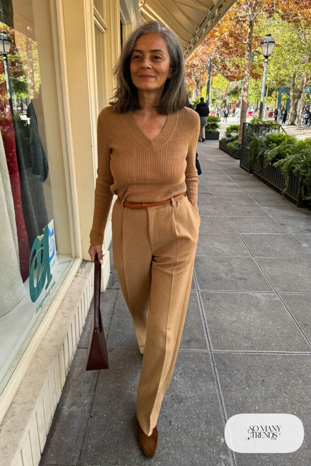 Petite woman in a camel V-neck sweater and matching camel straight pants with brown suede flats, outfit 7