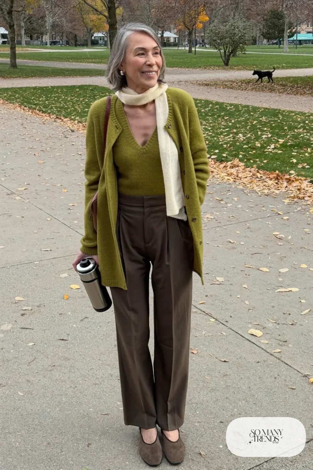 Petite woman in an olive knit top, olive straight pants and olive hip-length cardigan with a cream scarf, outfit 11