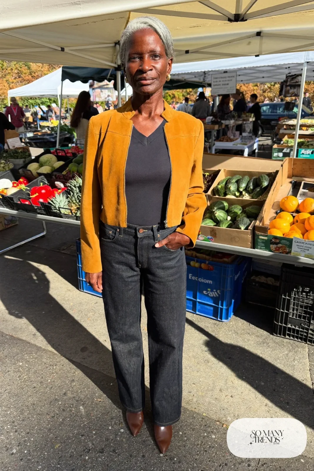 Petite woman in a cropped mustard jacket over a navy top and dark straight jeans with loafers, outfit 12
