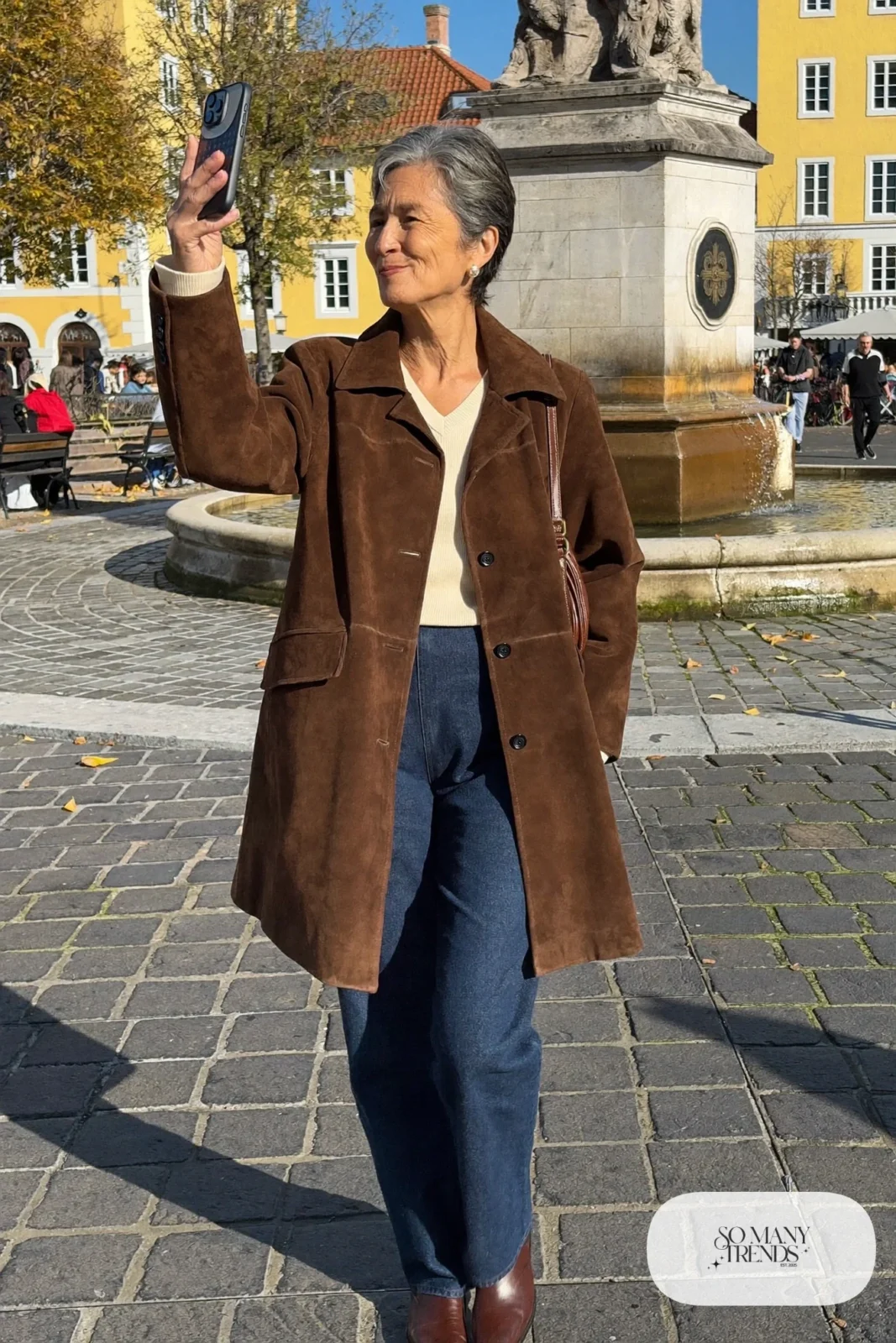 Petite woman in a hip-length brown suede jacket over a cream tee and dark straight jeans with brown boots, outfit 24