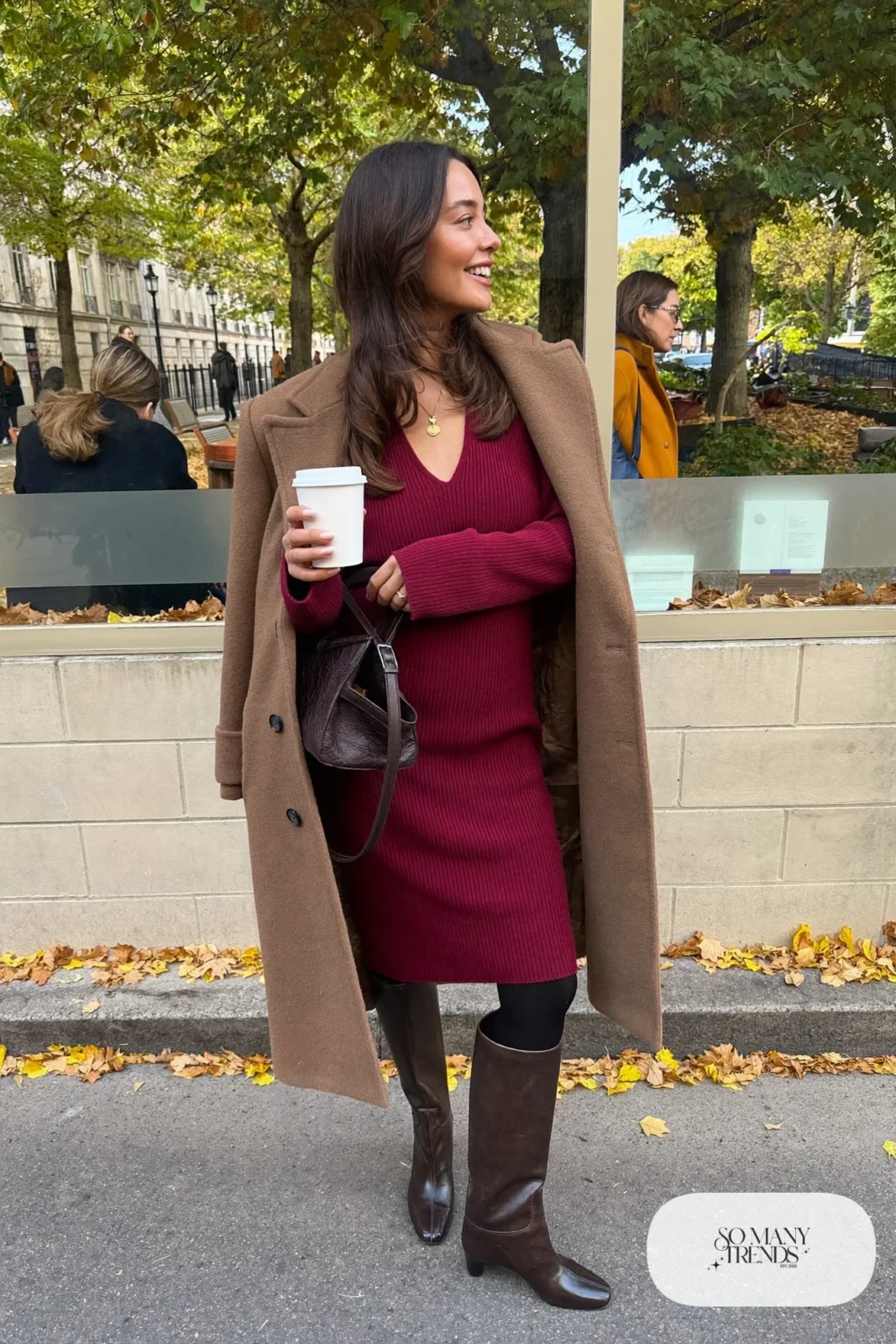 Woman in a burgundy V-neck ribbed knit midi dress with tall boots and a camel coat, outfit 5