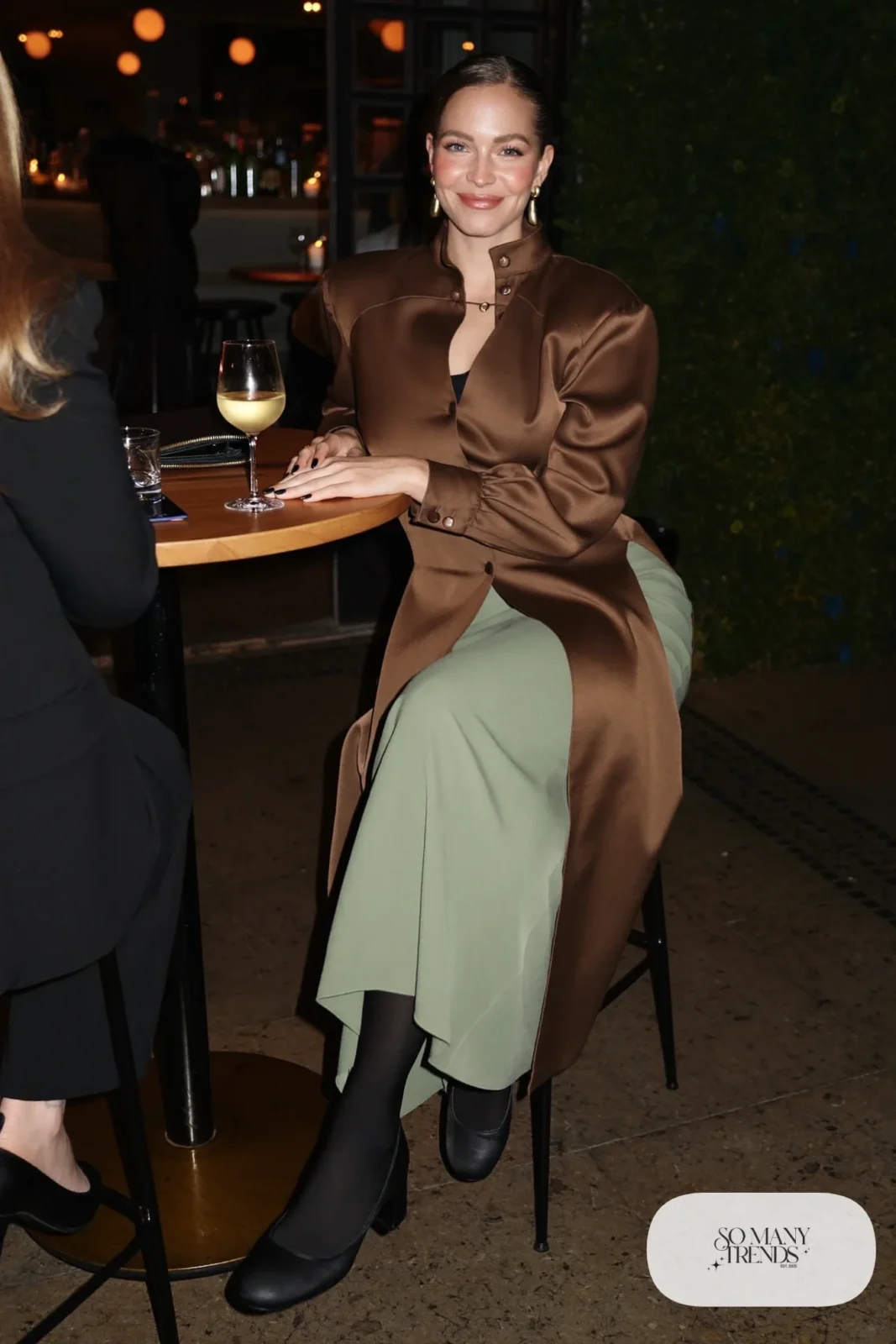 Woman in an espresso satin V-neck blouse with a sage midi skirt and block heels, outfit 7