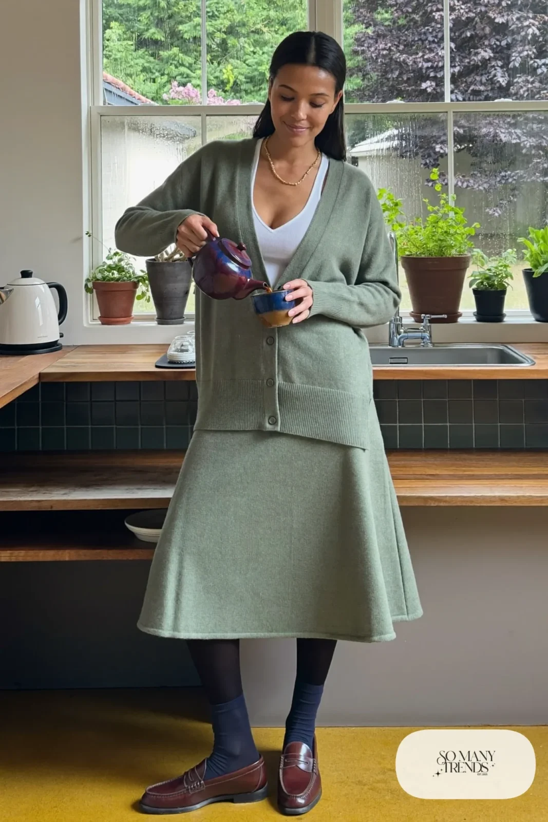 Woman in an oatmeal ribbed knit cardigan and midi skirt set with a white tank and loafers, outfit 17