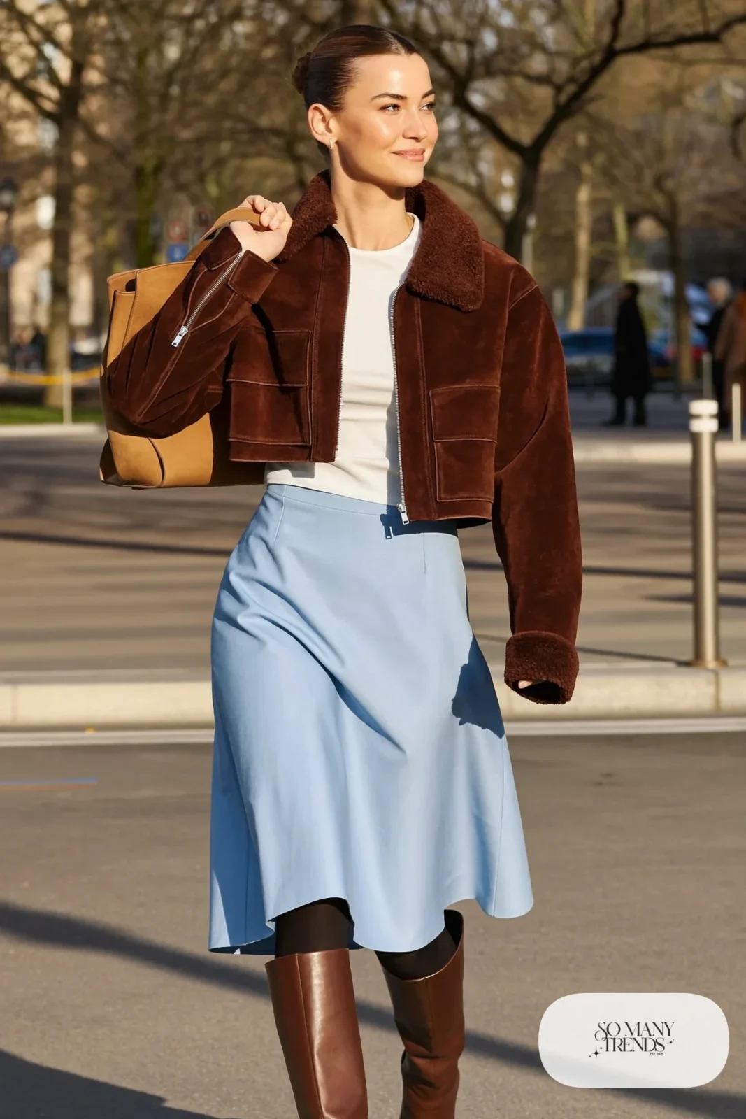 Woman with a straight athletic figure in a cropped brown suede jacket, a high-waisted baby blue A-line midi skirt and tall brown boots, outfit 6