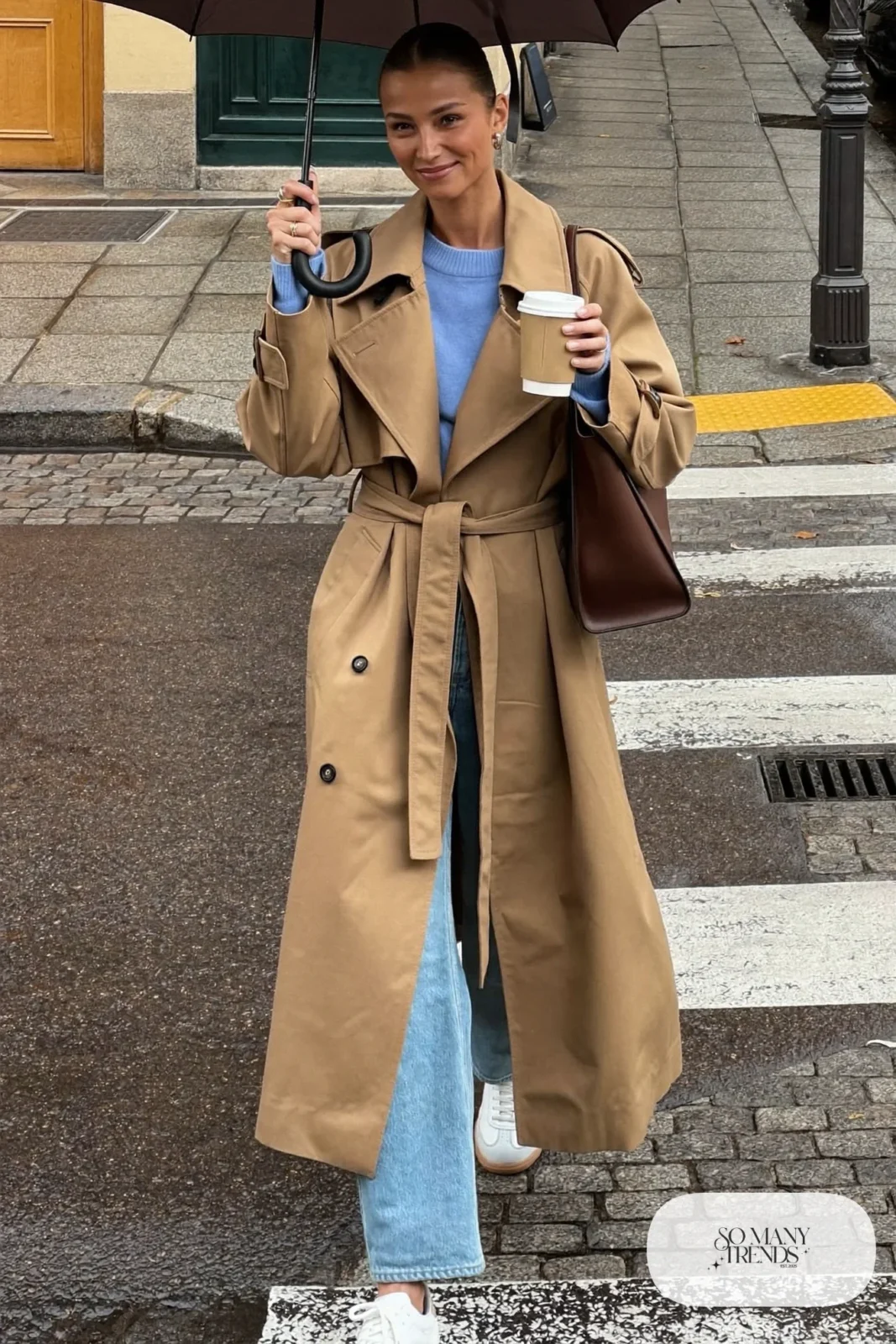 Woman with a straight athletic figure in a sand belted trench coat, cropped straight jeans, white sneakers and a brown tote, outfit 9