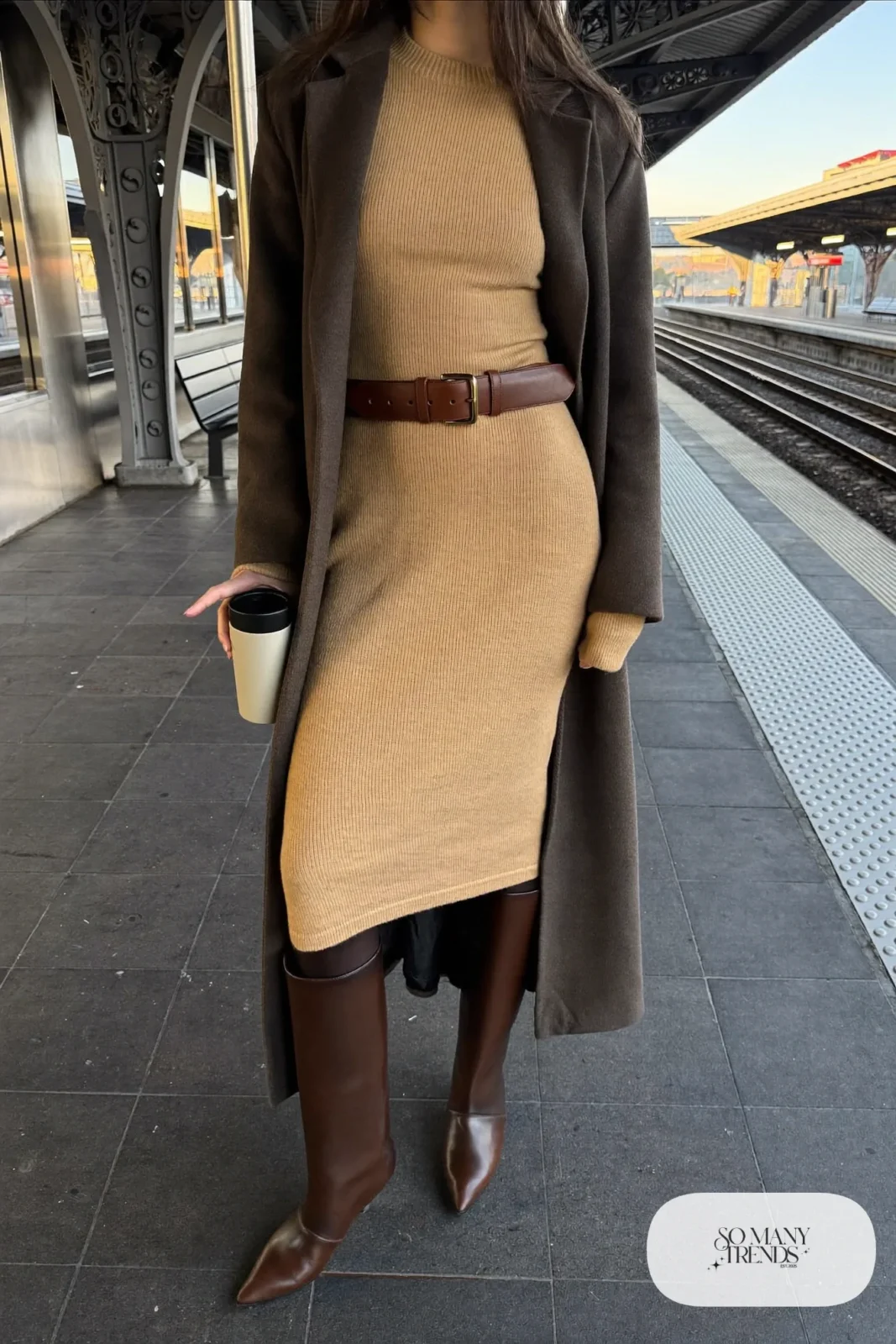 Woman with a straight athletic figure in a sand ribbed knit midi dress with a brown belt, tall boots and a long coat, outfit 17