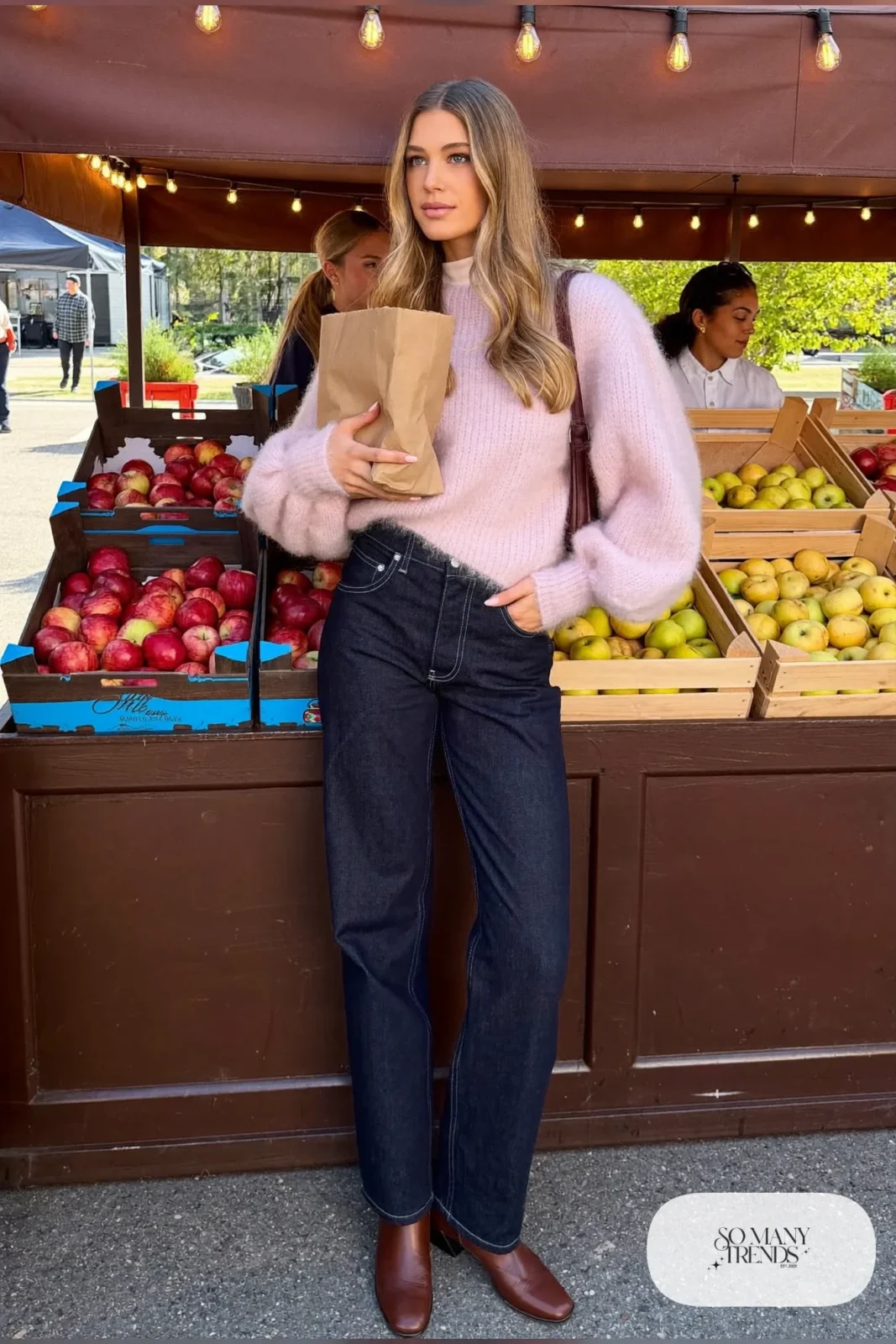 Woman with pear-shaped figure in a pale pink bishop-sleeve sweater, dark high-rise jeans and brown ankle boots, outfit 7