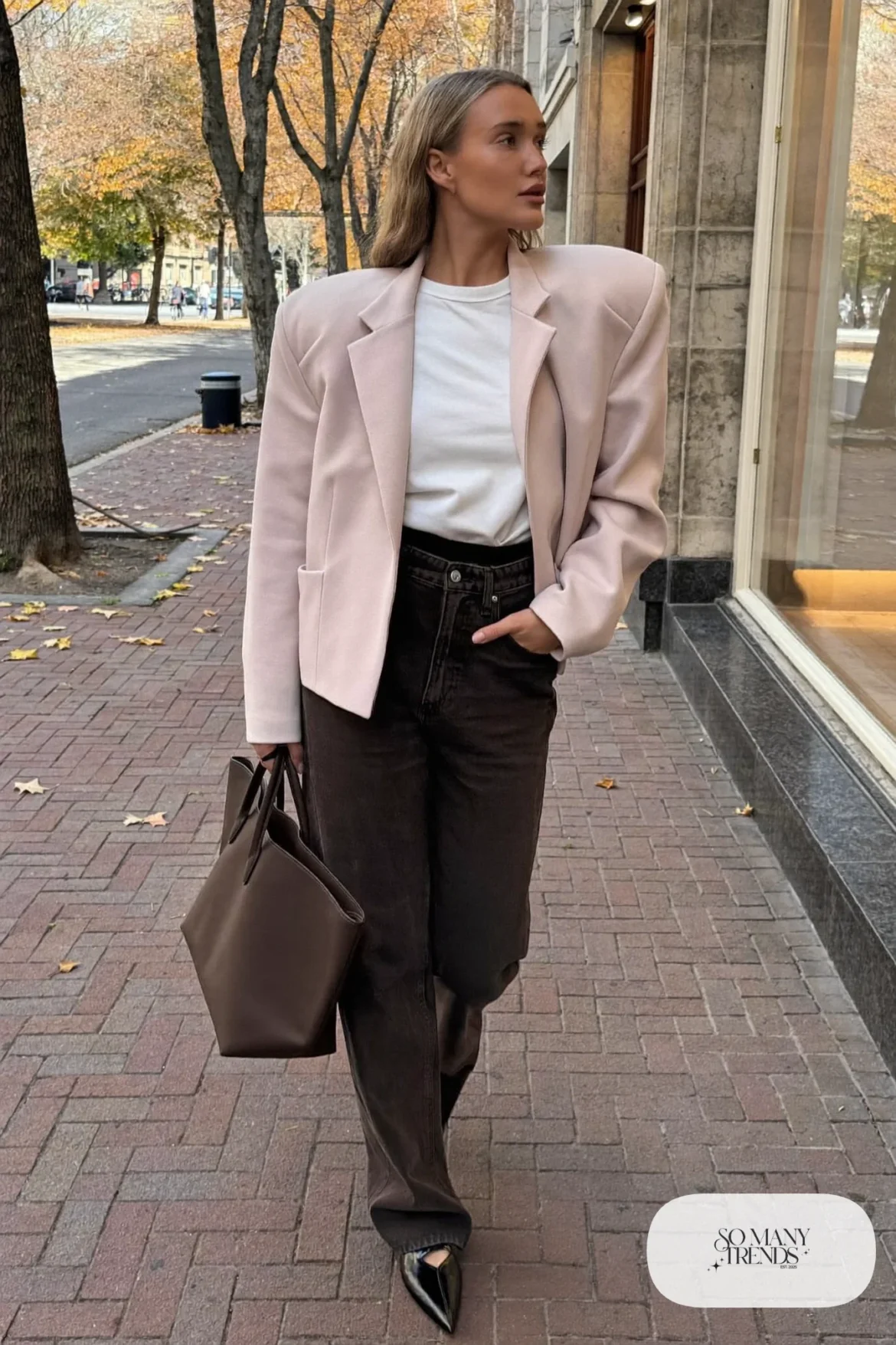 Woman with pear-shaped figure in a pale pink structured-shoulder jacket, white tee, dark jeans and pointed flats, outfit 22