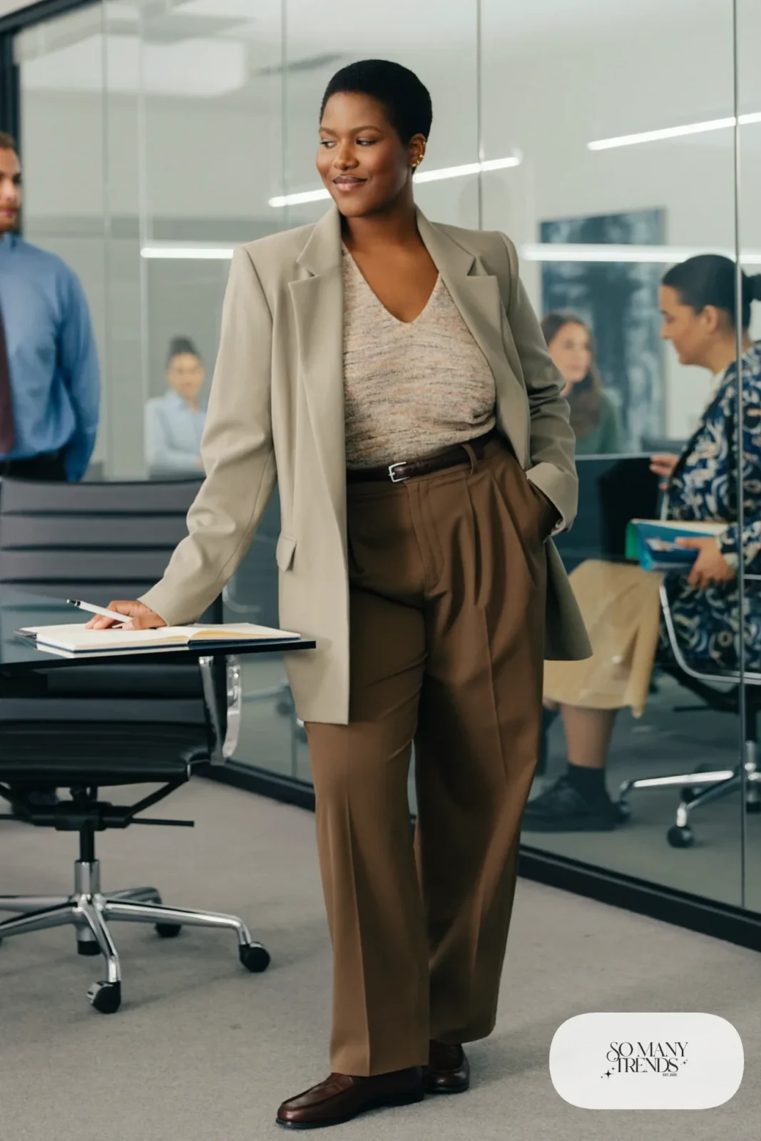 Woman in long sage crepe blazer, oatmeal V-neck knit, espresso high-waisted wide-leg pants and brown loafers, outfit 1