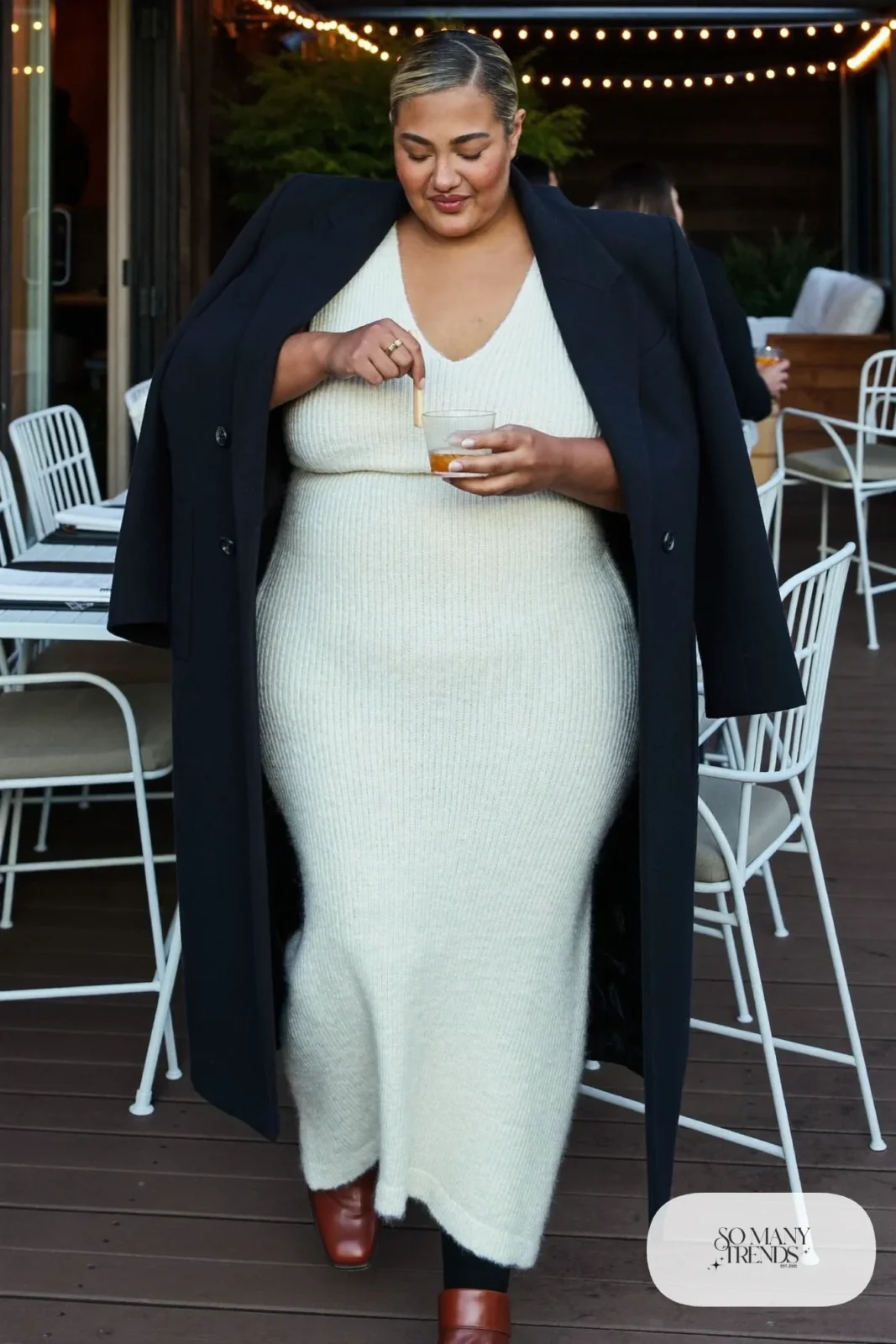 Plus size woman in ivory knit maxi dress with navy long coat and brown ankle boots, outfit 6