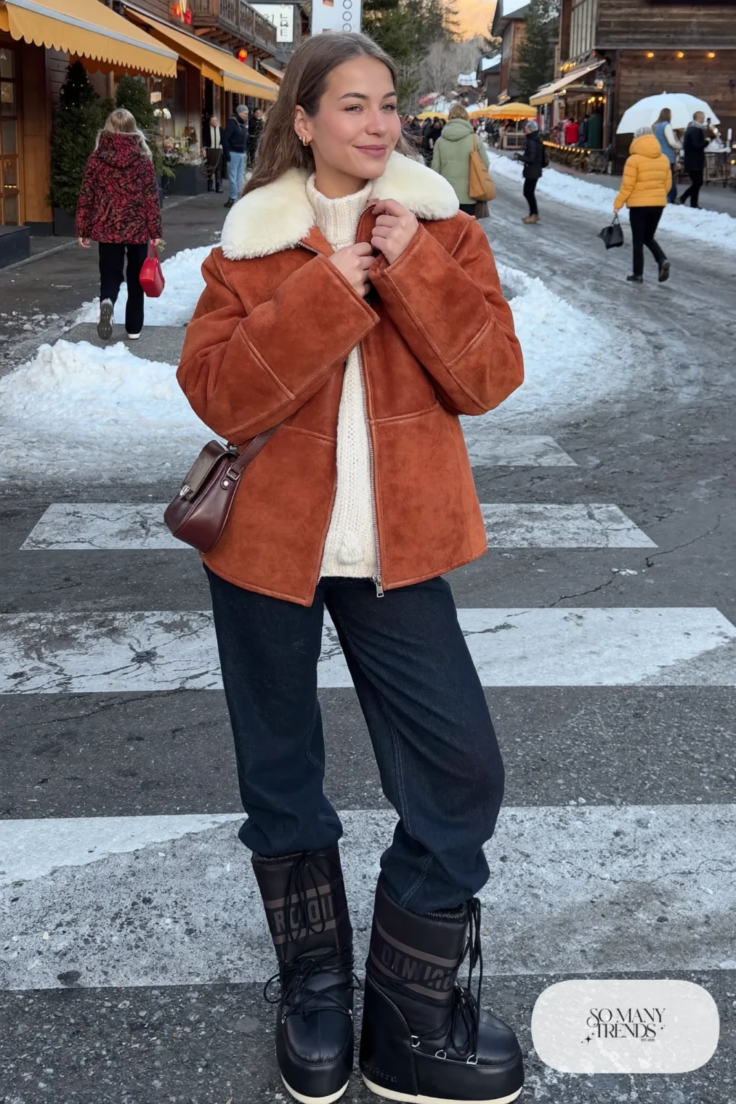 Woman in terracotta suede-look shearling collar jacket, cream knit, dark jeans and black moon boots, outfit 17