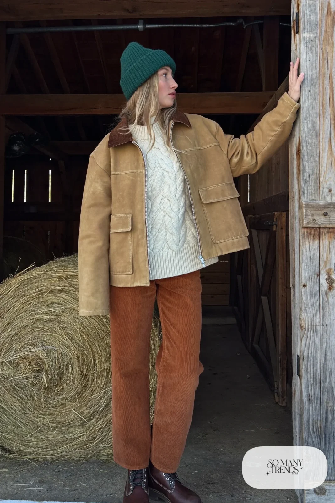Cream cable-knit sweater under tan waxed canvas barn jacket with rust corduroy pants and brown lace-up boots, outfit 2