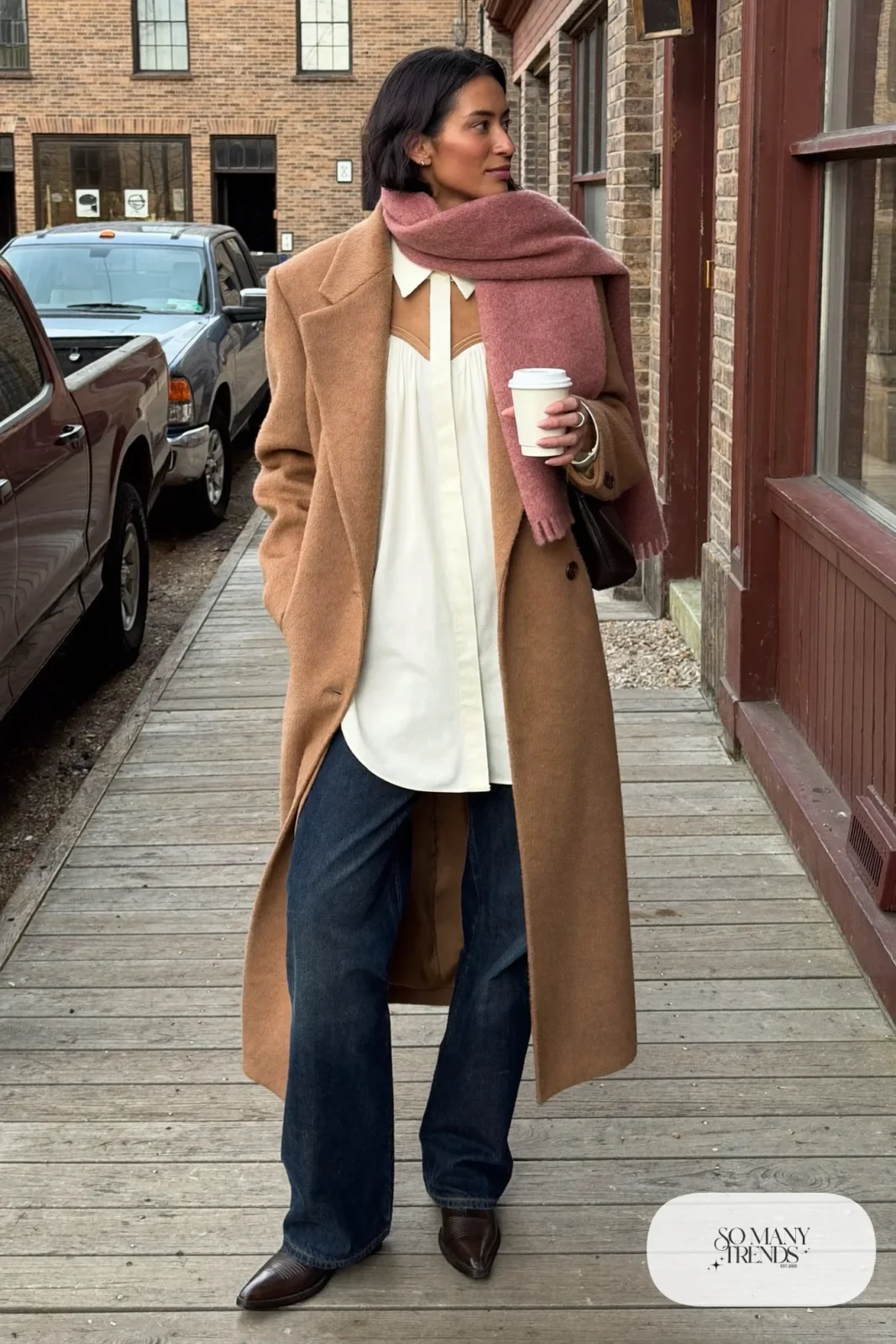 White pearl-snap western shirt under long camel wool coat with wide-leg dark jeans and pointed brown boots, outfit 3