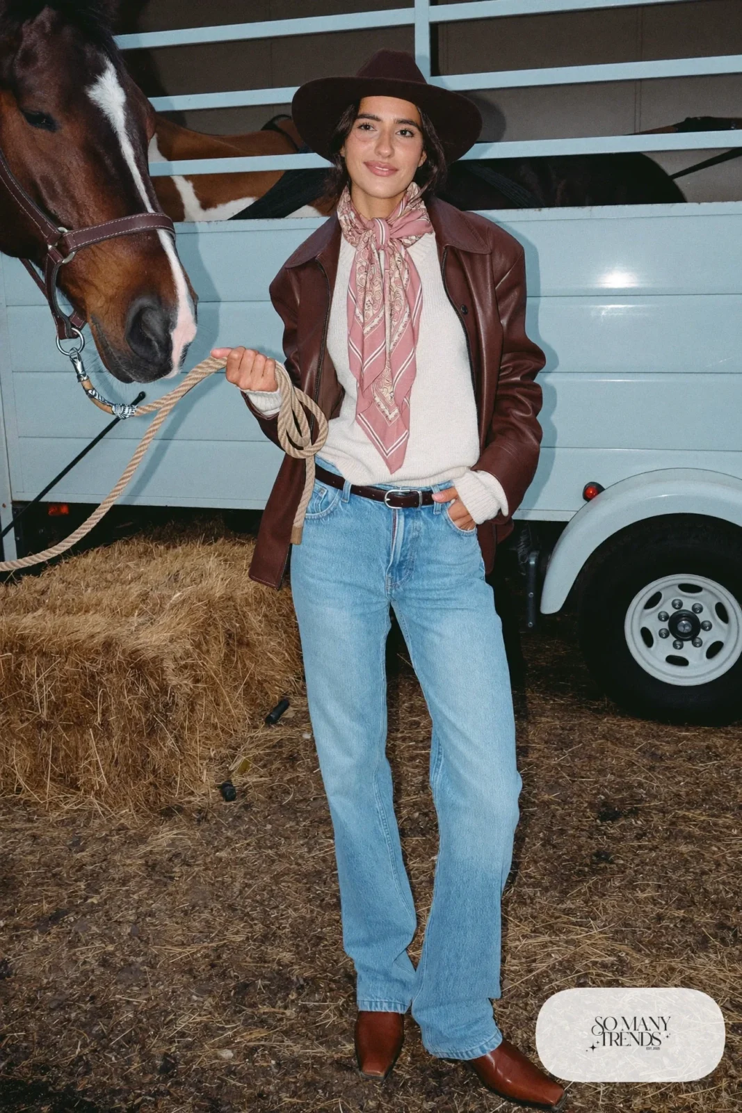 Rose bandana at neck with brown leather jacket over cream sweater, straight light jeans and cognac boots, outfit 12