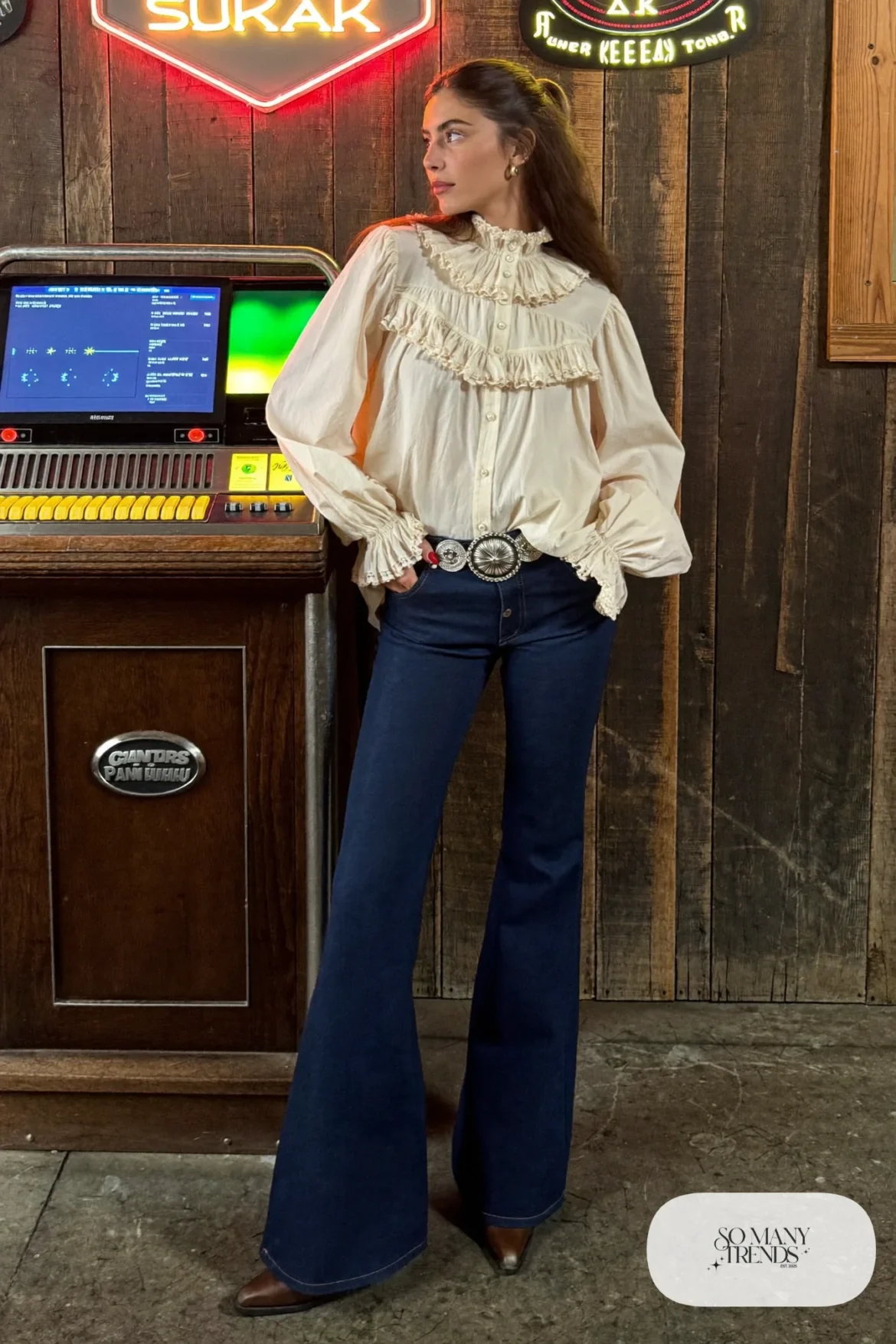 Cream ruffled western blouse tucked into dark flared jeans with brown pointed boots and concho belt, outfit 20
