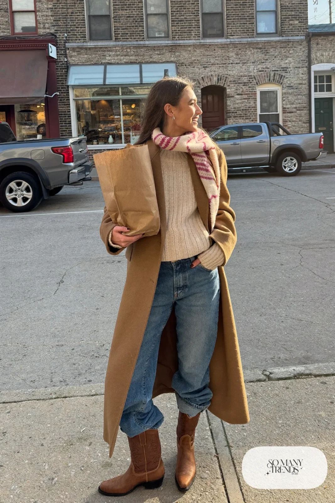 Long camel wool coat over cream knit with straight jeans, rose scarf and tan cowboy boots, outfit 27