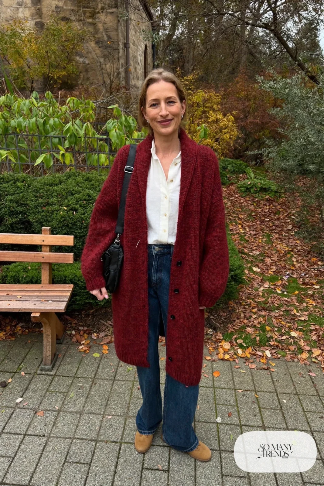 Long burgundy shawl-collar cardigan, white collared blouse, dark jeans and tan loafers - outfit 19
