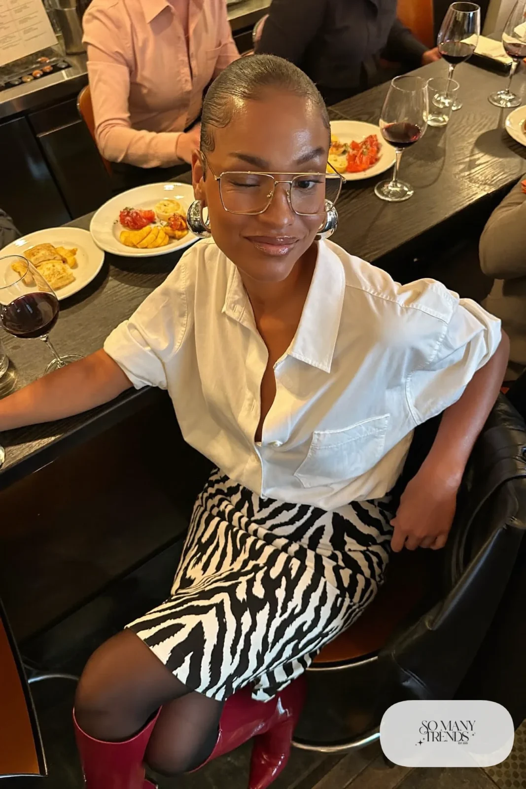 Black and white zebra print pencil midi skirt, crisp white oversized shirt, glossy red knee boots and silver hoops, winter date outfit 9