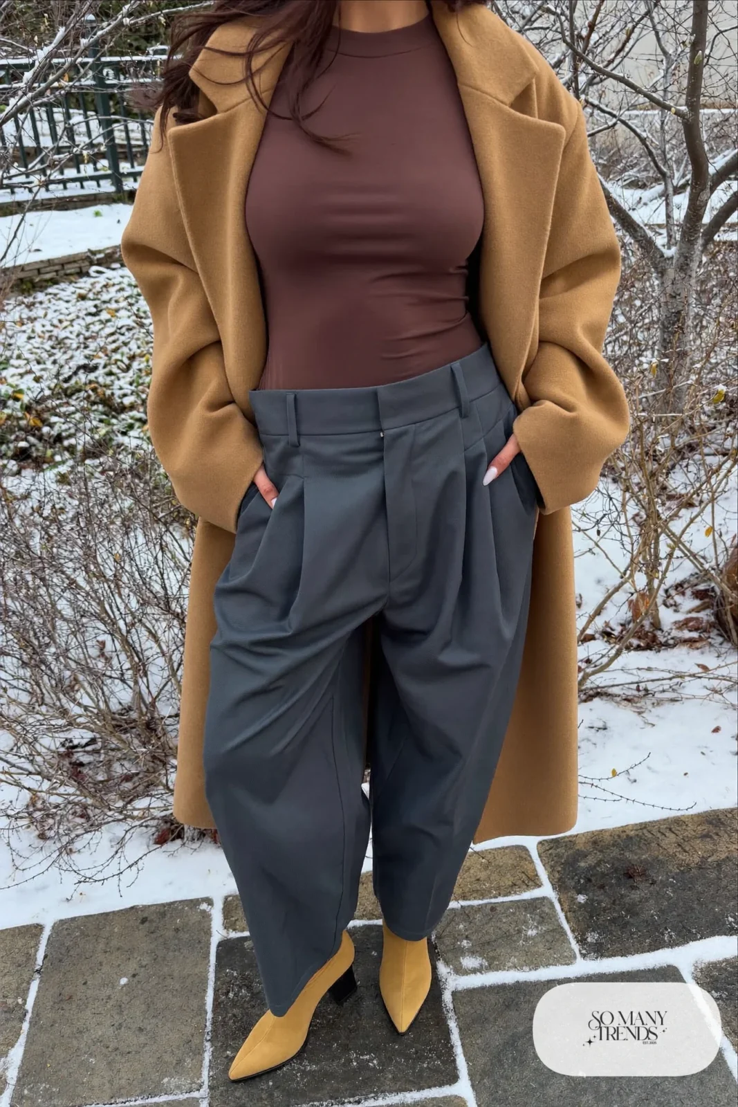 Woman in a forest green ribbed knit midi dress, black opaque tights and tall black boots in a snowy garden, outfit 12