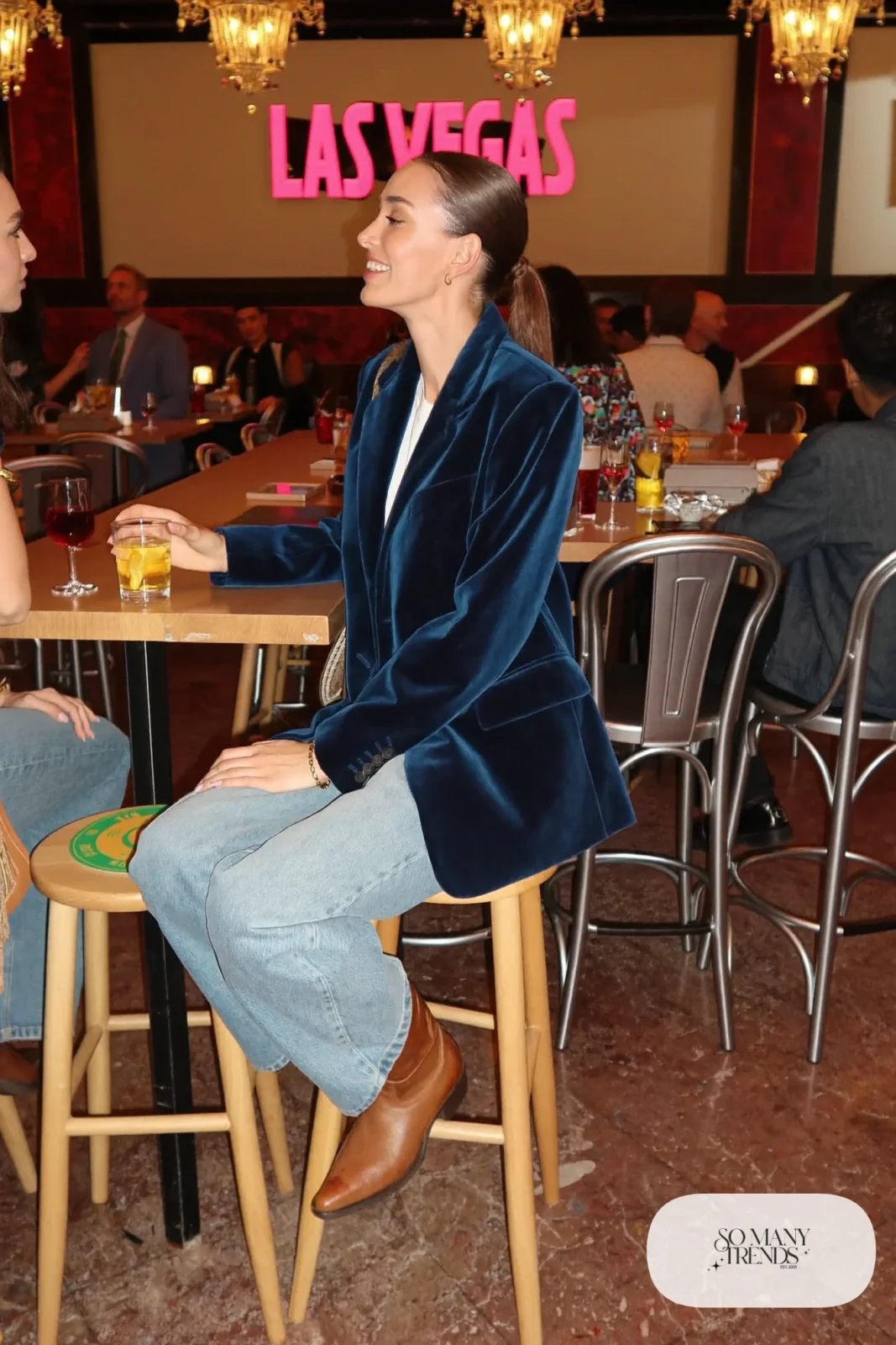 Woman in ink blue velvet blazer, white tee, wide-leg light wash jeans and tan boots, NFR outfit 13