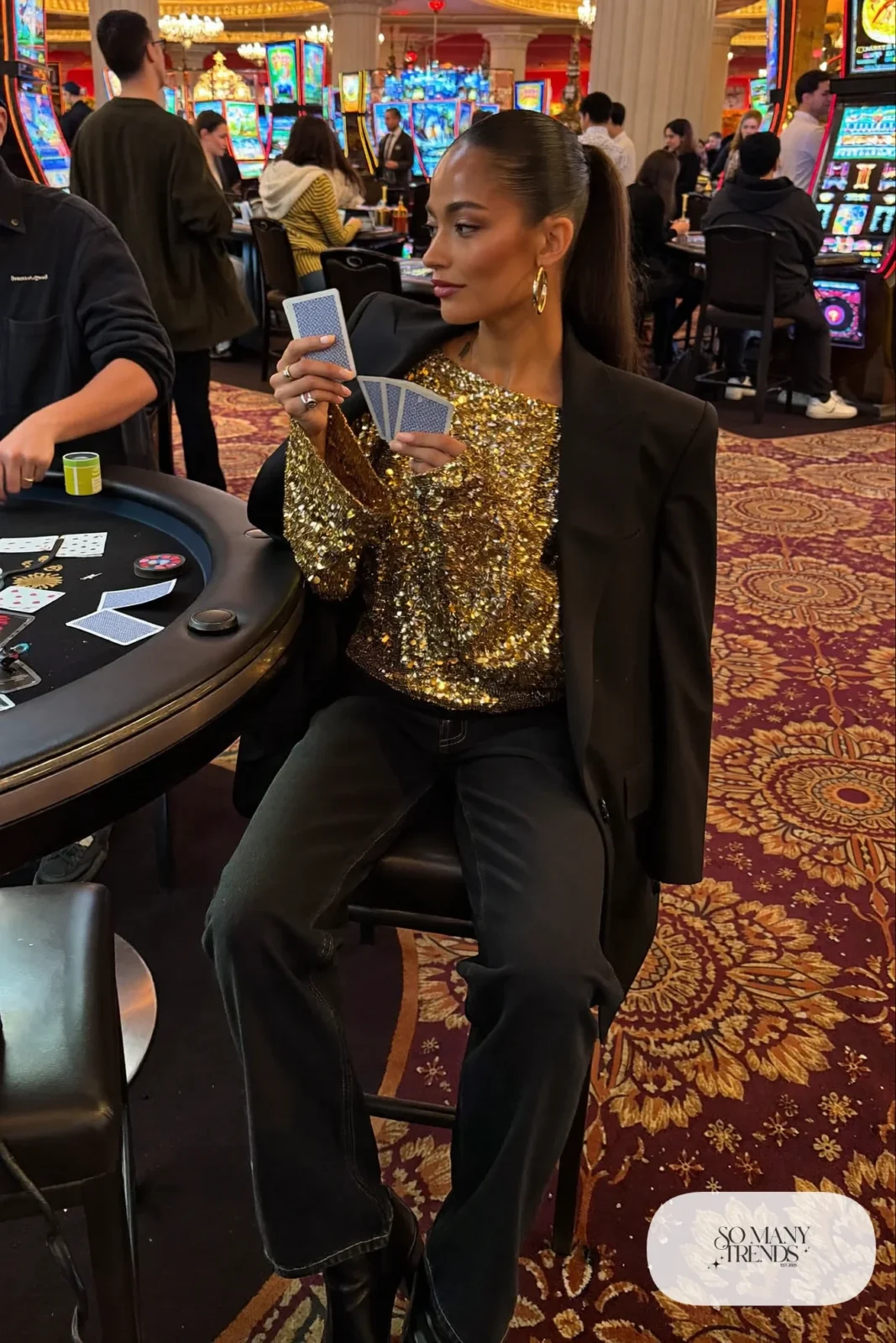 Woman in gold sequin top, black blazer, black straight jeans and black boots, NFR outfit 20